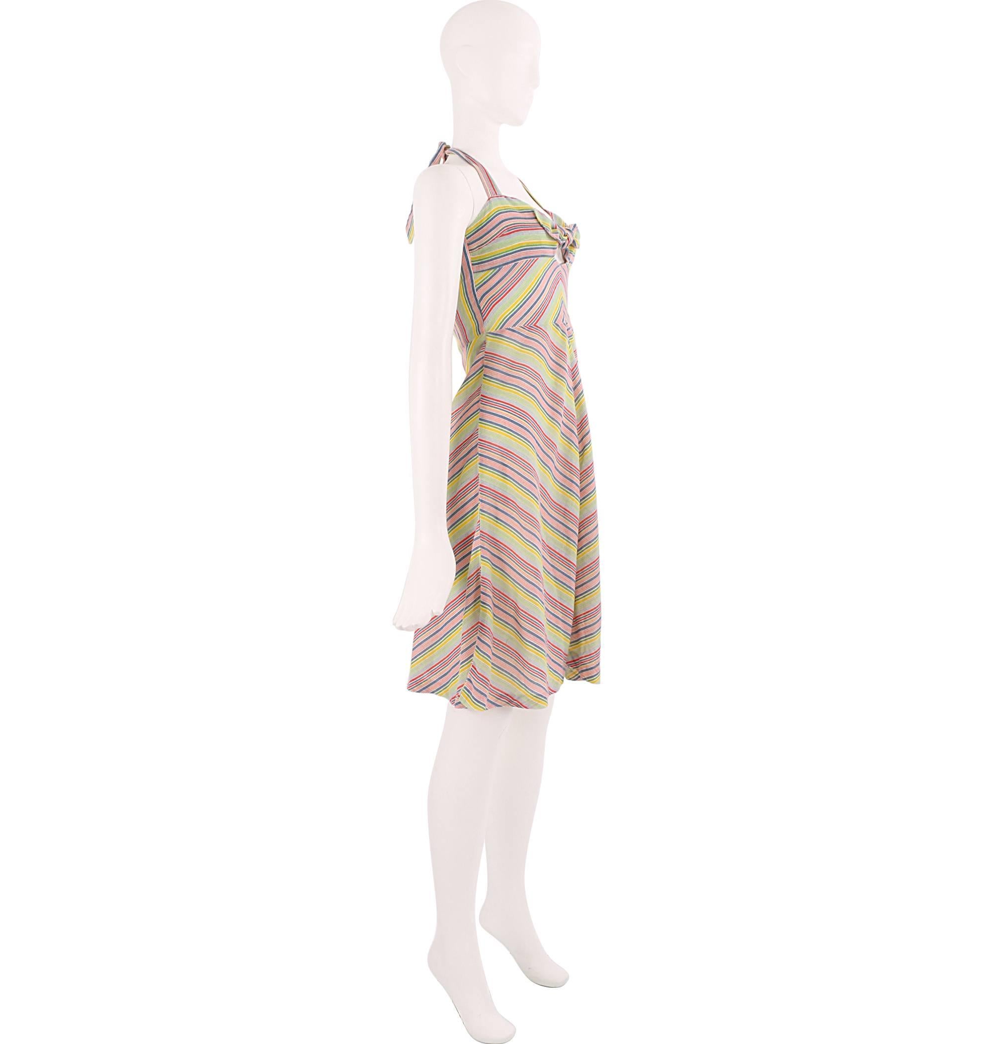 Fun 1970s halterneck tie dress featuring a bright rainbow coloured chevron striped print and cute central bow detailing. If you're looking for a vibrant and pretty staple summer dress then this is the piece for you. Sweet and sassy, the garment is