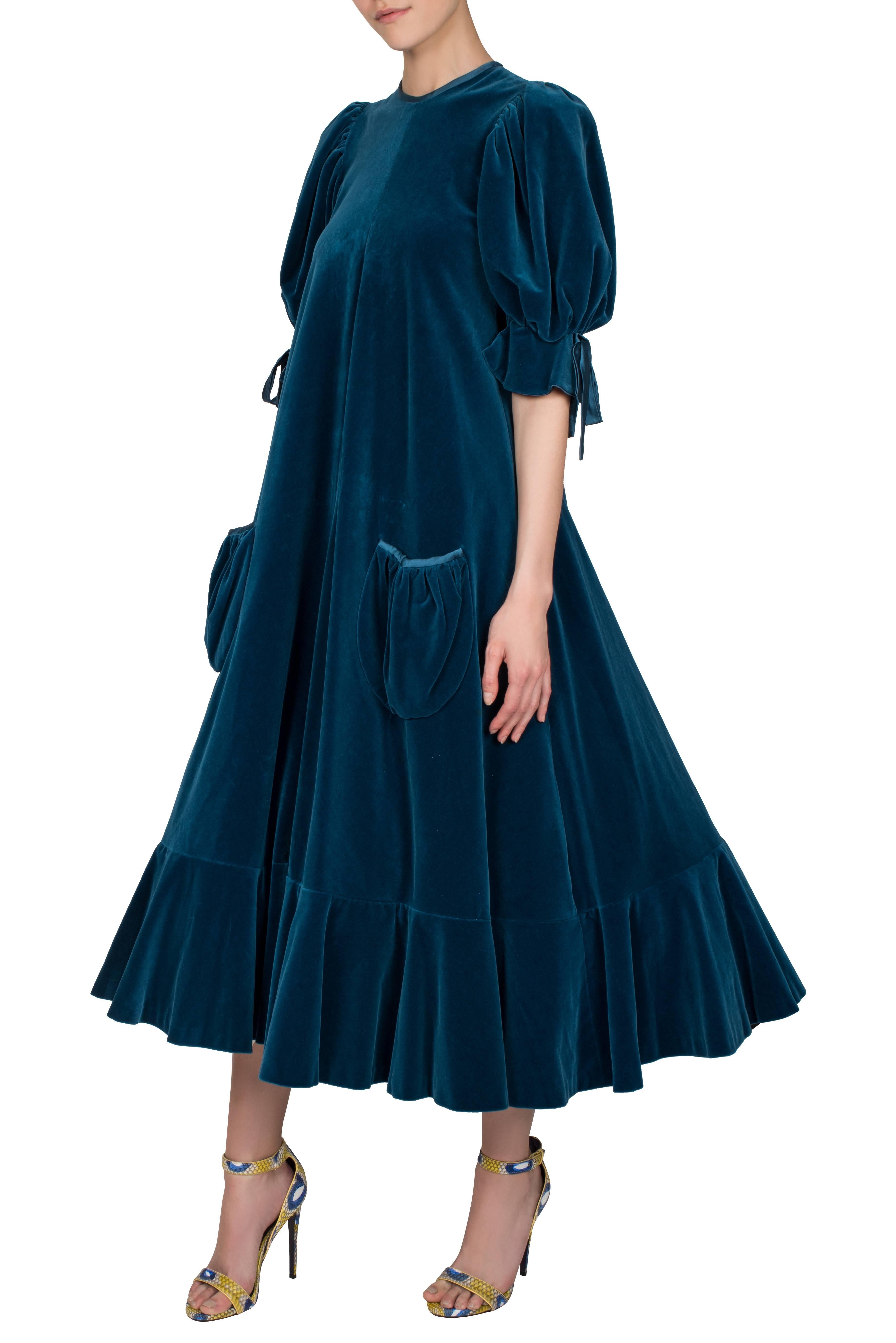 A rare Gina Fratini petroleum blue cotton velvet dress with puff sleeves and ivory lace-trimmed petticoat. This heavy full-length dress features a high round neckline, two gathered pouch silk-trimmed pockets on the hips and elbow-length puff sleeves