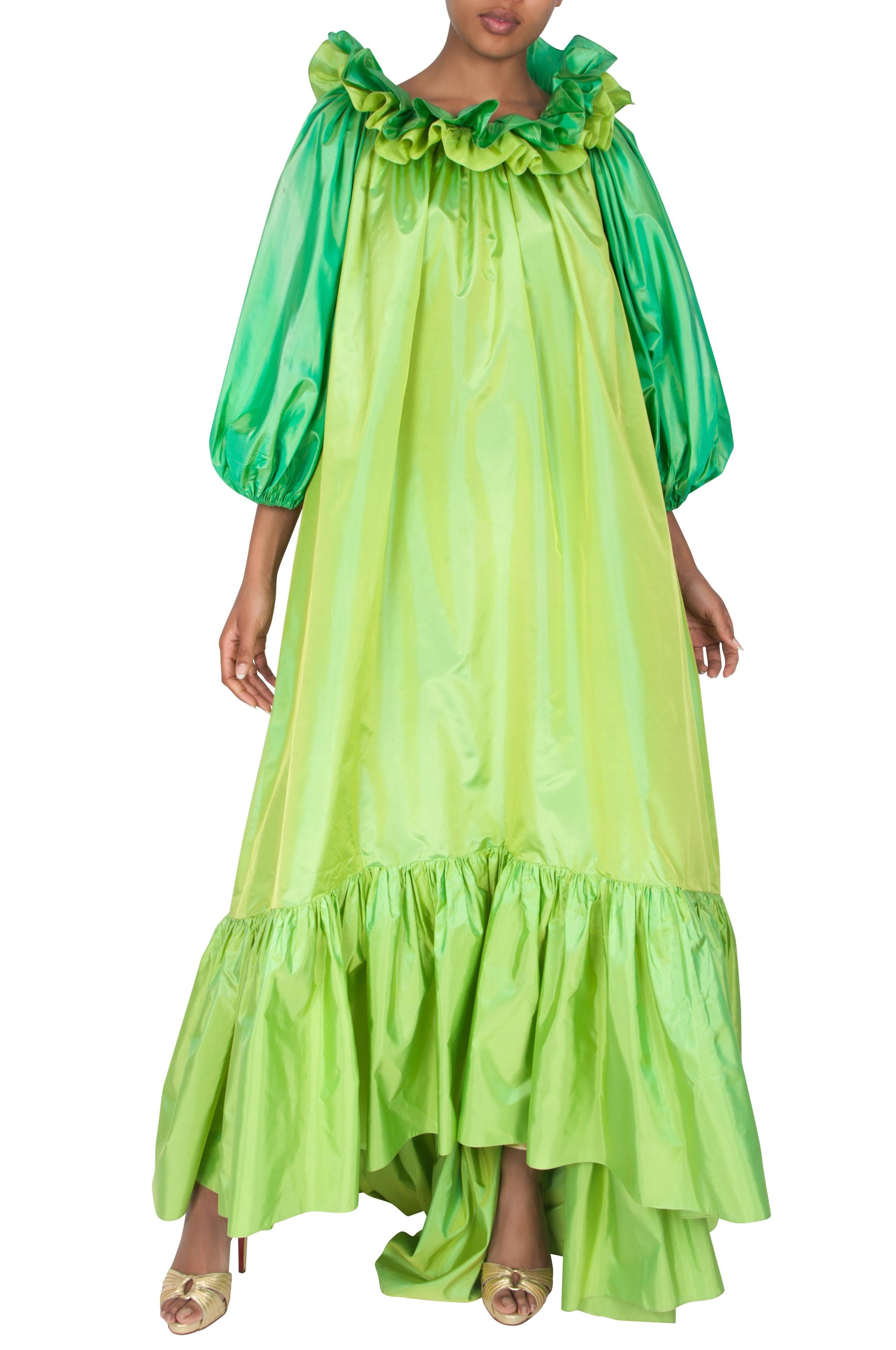 A stunning rare Yves Saint Laurent couture lime green silk ball gown. The full-length dress has a loose A-line shape and features dramatic puffed emerald green three-quarter length sleeves and a layered two-tone ruffled collar. The tiered hem
