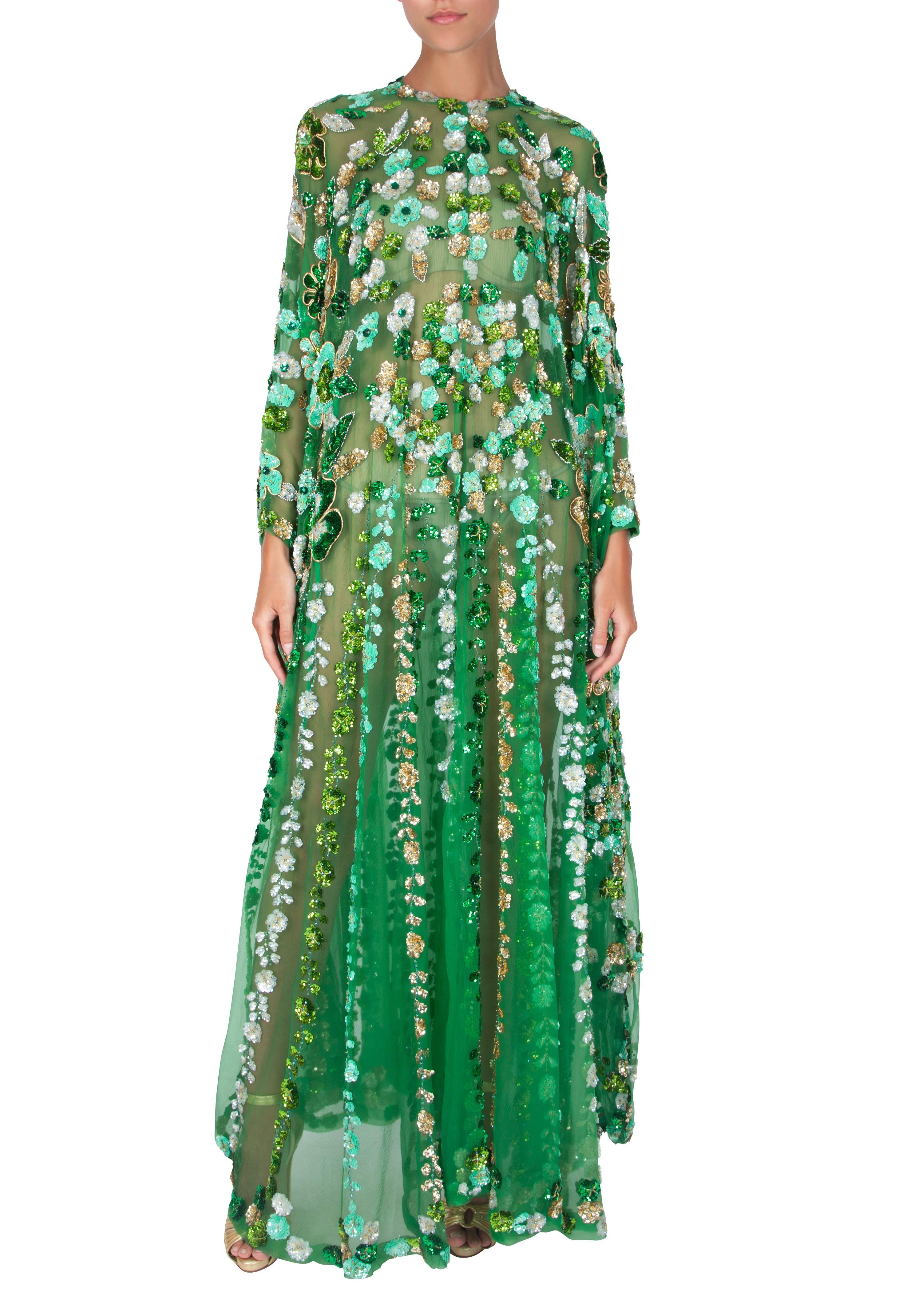 A striking emerald green silk chiffon caftan with gold and green floral sequin embroidery all over from London boutique Arabesque. This heavy, full-length caftan slips on over the head and features a shallow V-neck. The translucent emerald green