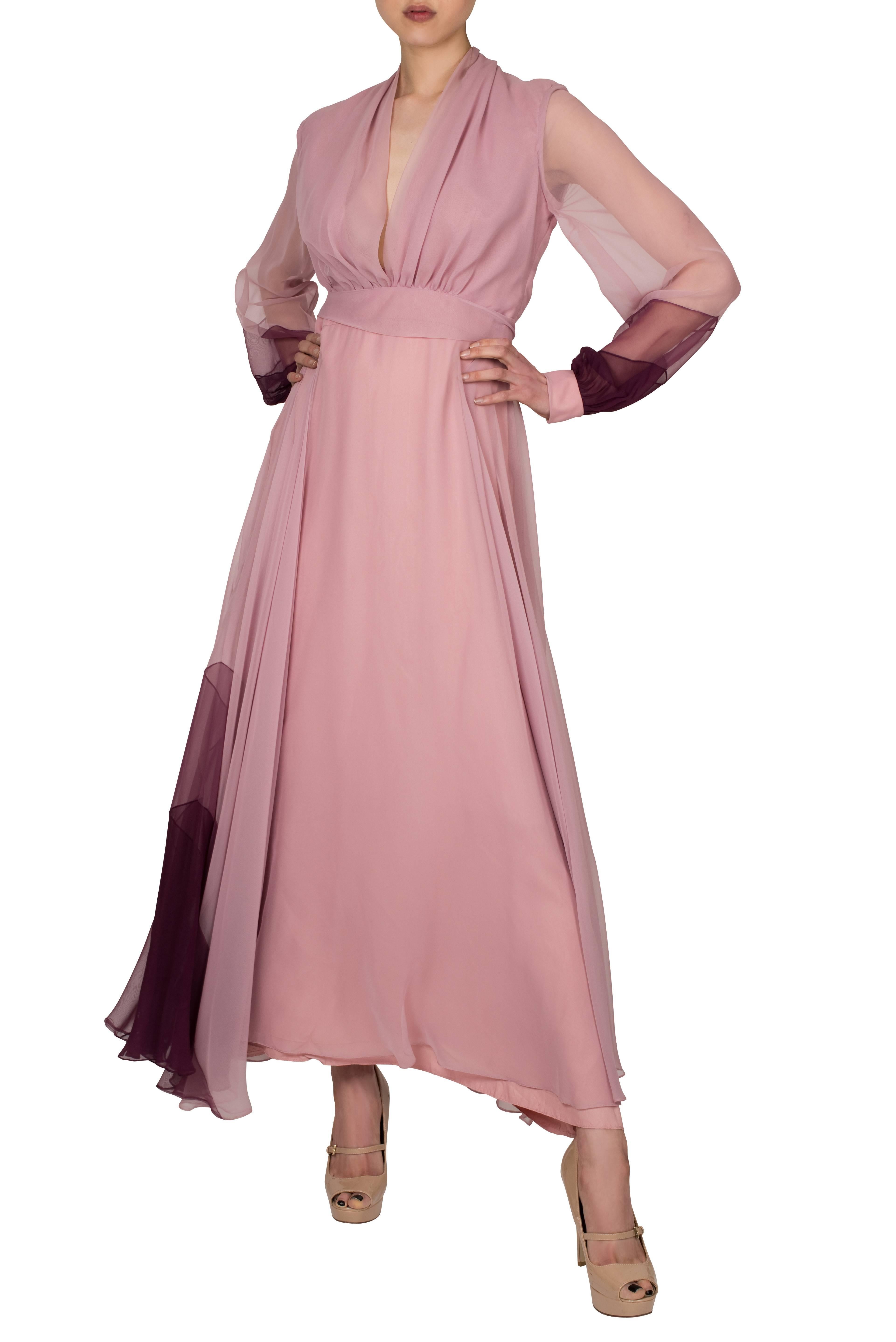 Stunning 1970's gown with a shawl neckline which flatters the décolletage. With an empire waist accentuated by a belt in the same fabric, the dress features sheer sleeves with a darker insert on the cuffs. A flared skirt complements the shape of