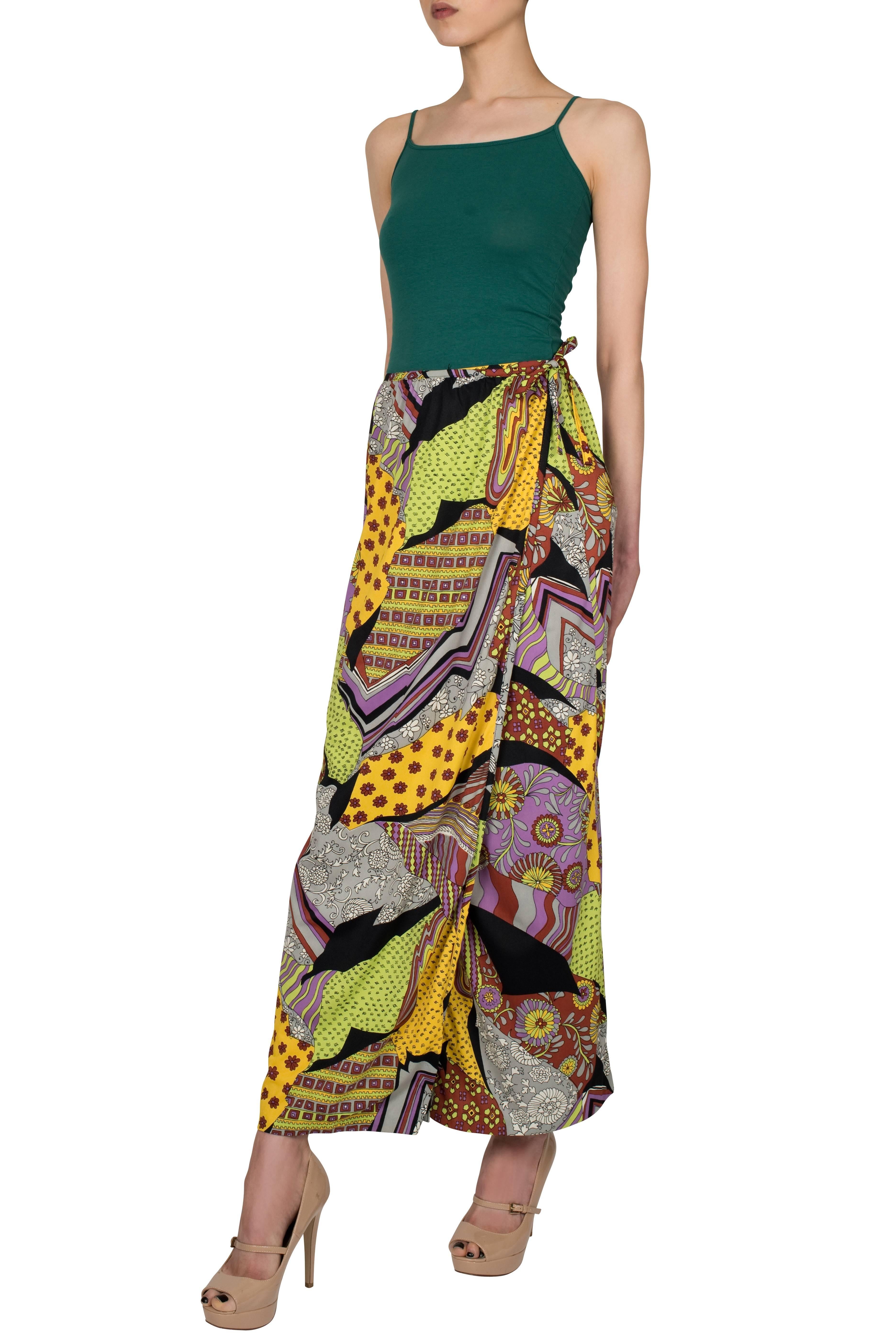 The patchwork of abstract and floral prints makes this 1970's long wrap around skirt by Donald Brooks for Sinclair stand out instantly. Its shape is simple, yet very flattering, and features two clasps along the waist for extra security. The
