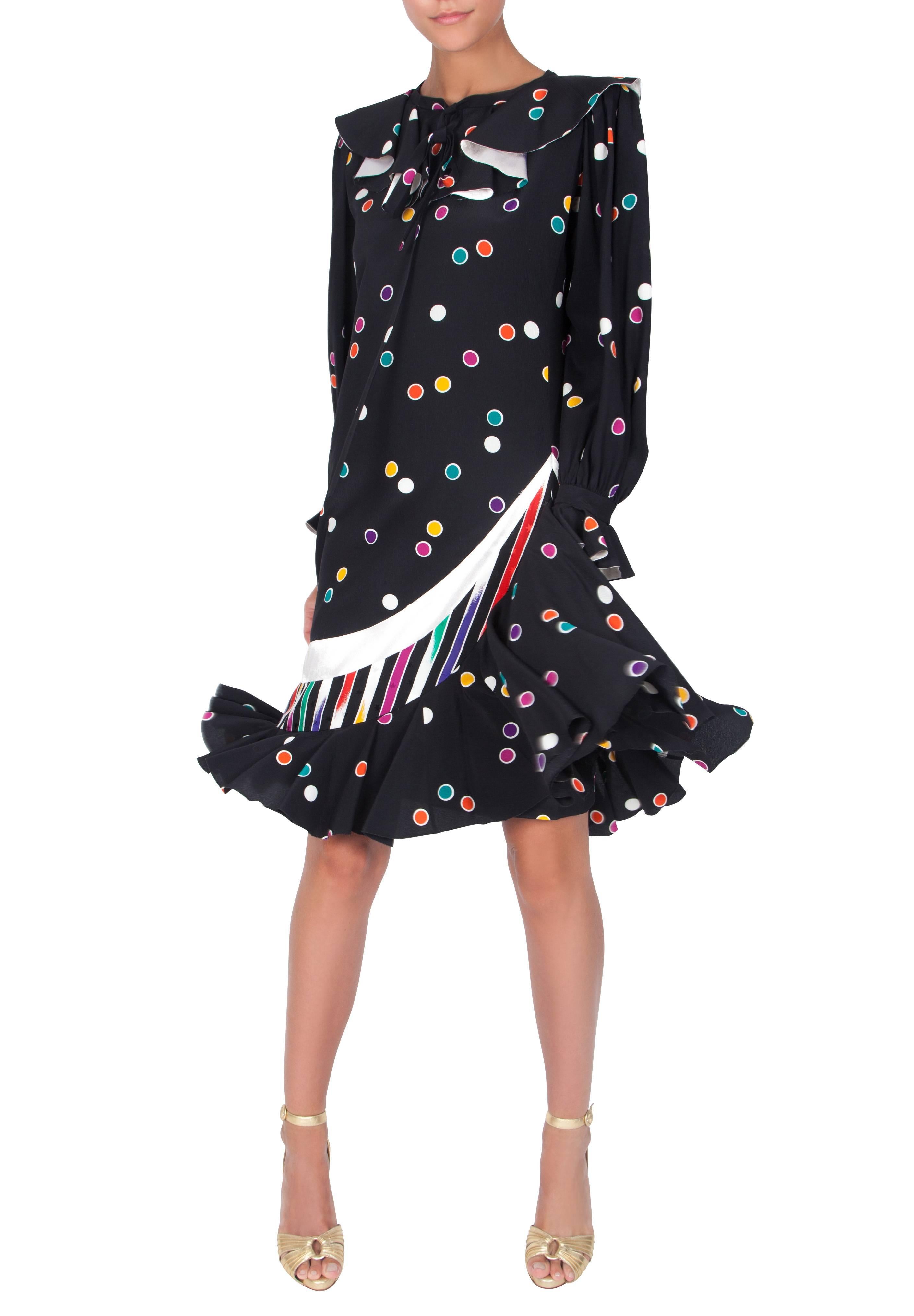 A playful 1980s Emanuel Ungaro Couture black silk midi dress with multicoloured polka dots and a waterfall hem. The dress features a ruffled round collar with a metallic silver reverse side and a necktie and full-length sleeves with ruffled cuffs