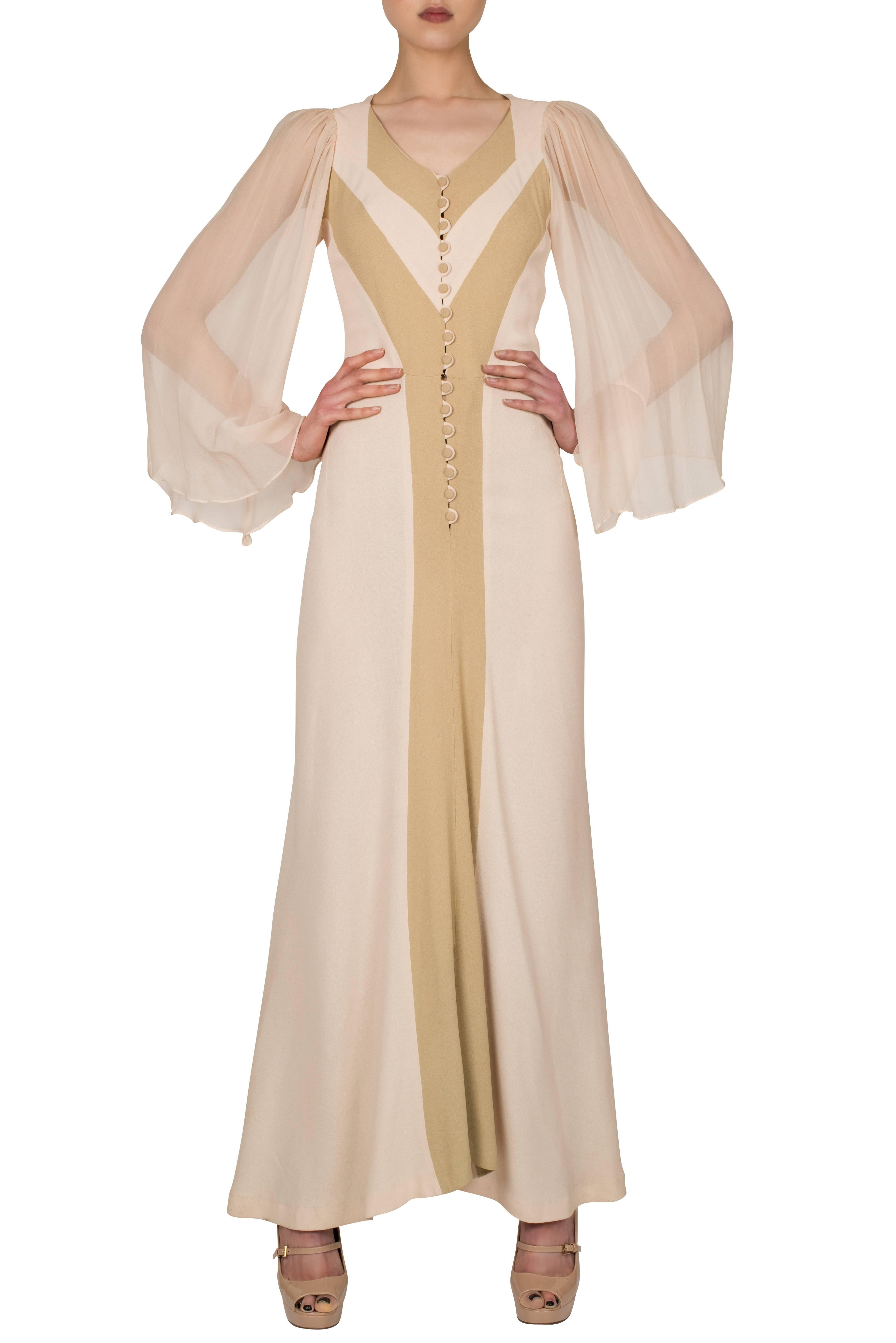 This 1970's Alice Pollock dress evokes the Déco style of the 1930’s whilst remaining true to its bohemian surroundings. The dress features a button down front, in ivory moss crepe with caramel colour vertical inserts adding to an elongated