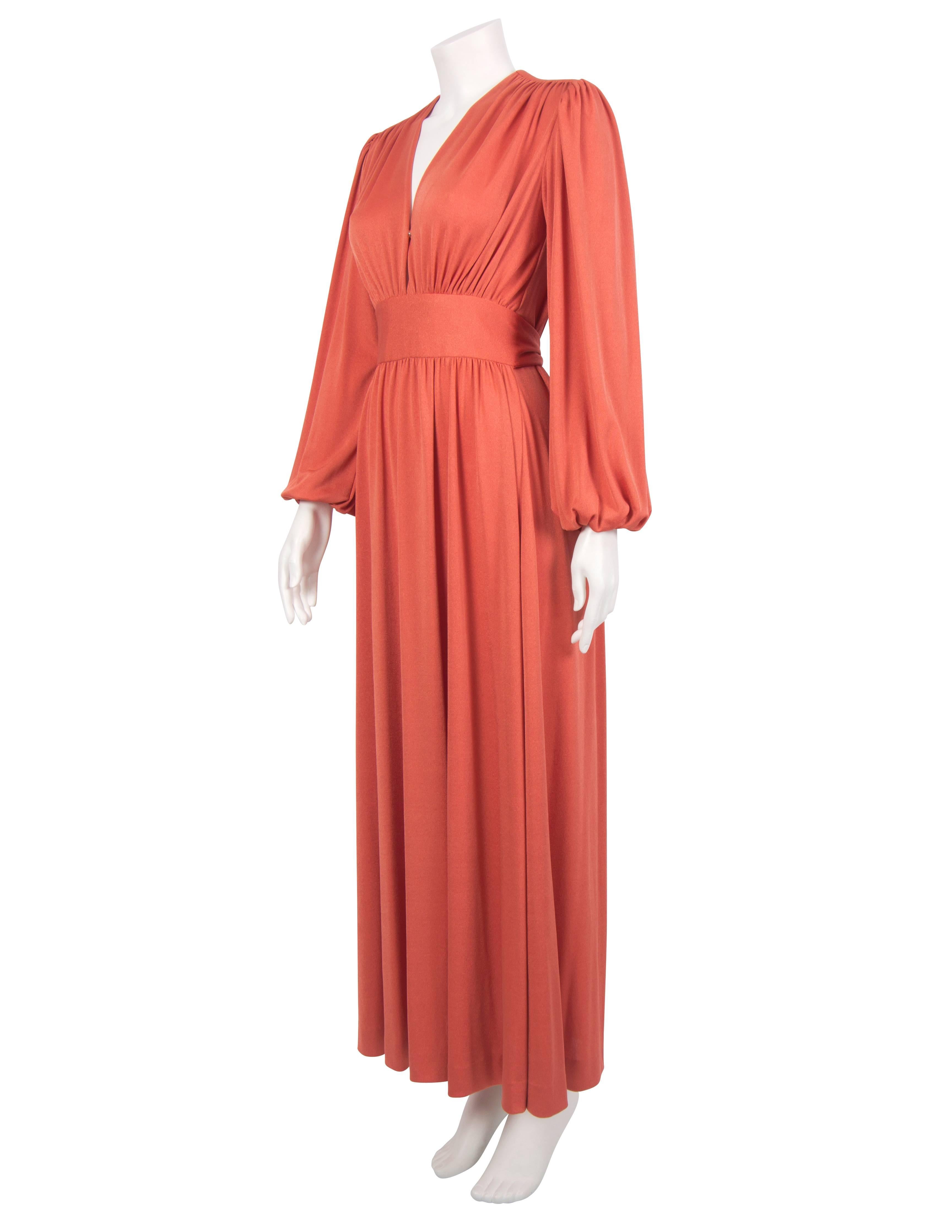 A gorgeous 1970's jersey dress featuring a plunging V neckline and poet sleeves. The dress has a fluid design with a draped bodice and sewn-in belts coming from the sides which tie around the waist, accentuating the décolletage. The skirt flows