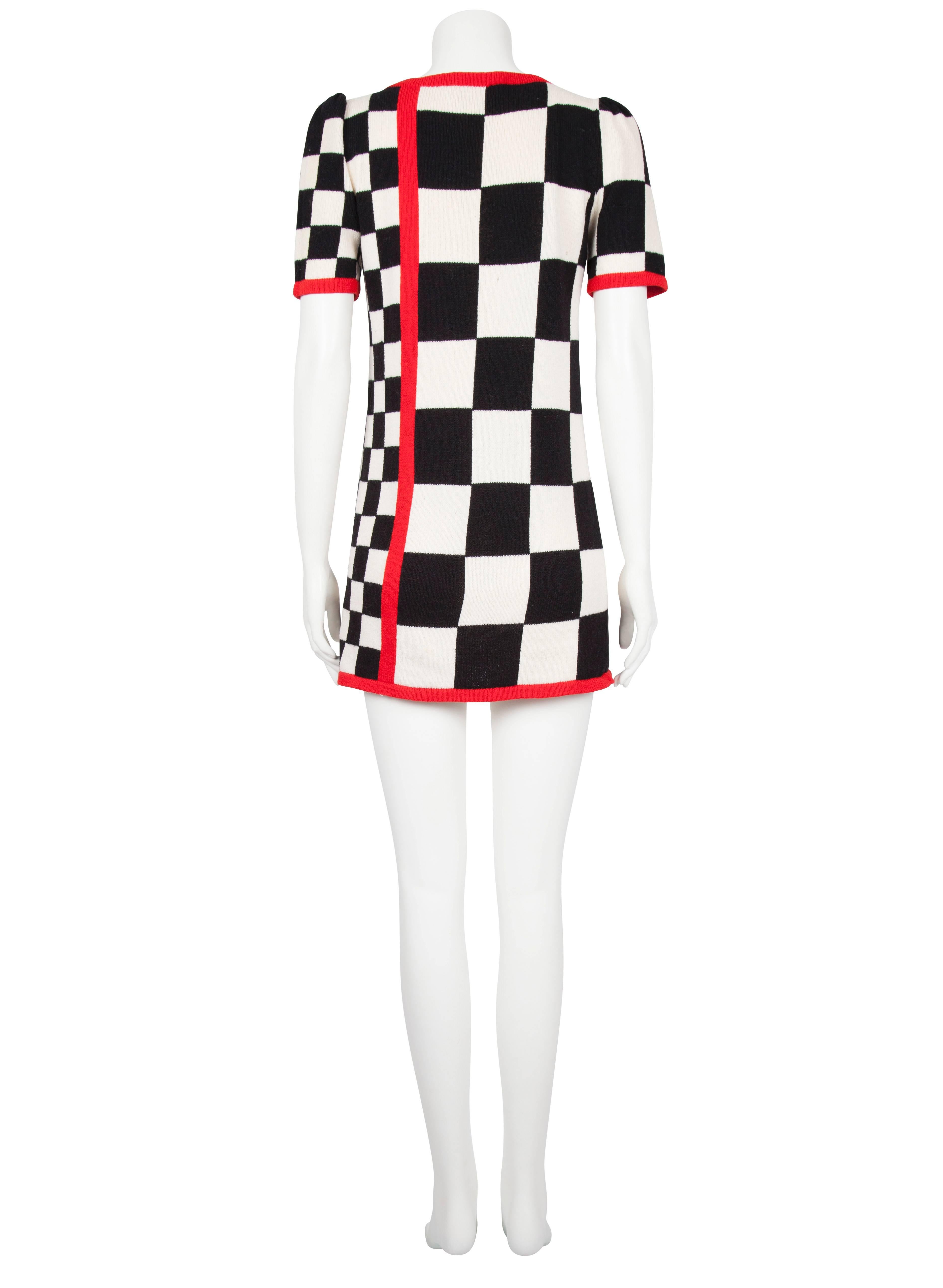 A 1980s Raul Blanco knitted mini dress featuring an all over racing flag pattern with a striking red detailing on the front left, cuffs and hem. The dress is a fitted shape and is unlined. Excellent vintage condition with no flaws to