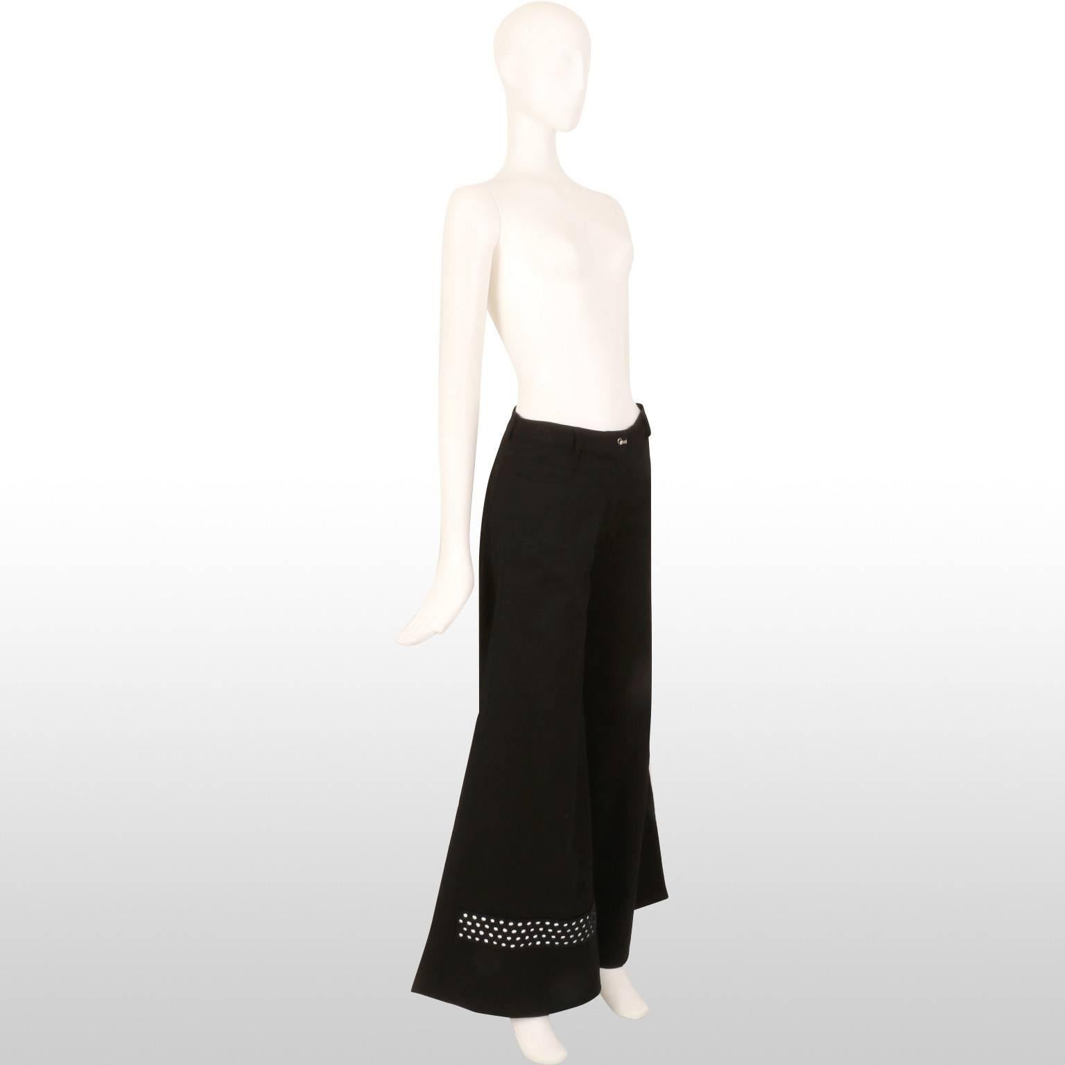 Black flared trousers by the fashion house Fendi. The bottom cuff of each leg is detailed with small mirrored discs and black beads. The waistband features a crystal encrusted metal clasp.