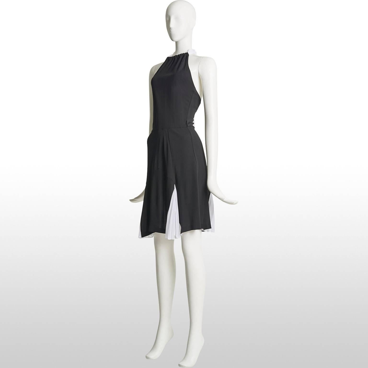 This is a black and white cocktail dress by the designer Diane Von Furstenberg. The dress has a gathered halter neck and is backless. At the bottom of the dress there are white triangular pleats which gives it a flair. The dress is kept in excellent