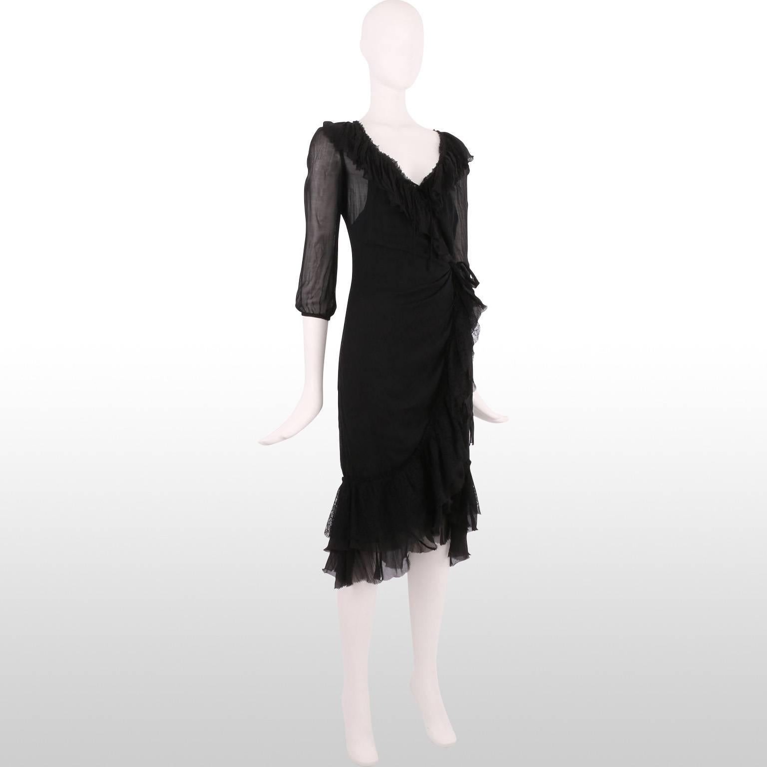 This is a very chic and delicate black sheer silk dress by the design house Prada. The dress has a V neckline, is wrapped & secured with a bow on the left hand side and has an attached black sleeveless underdress. Along the trim of the dress there