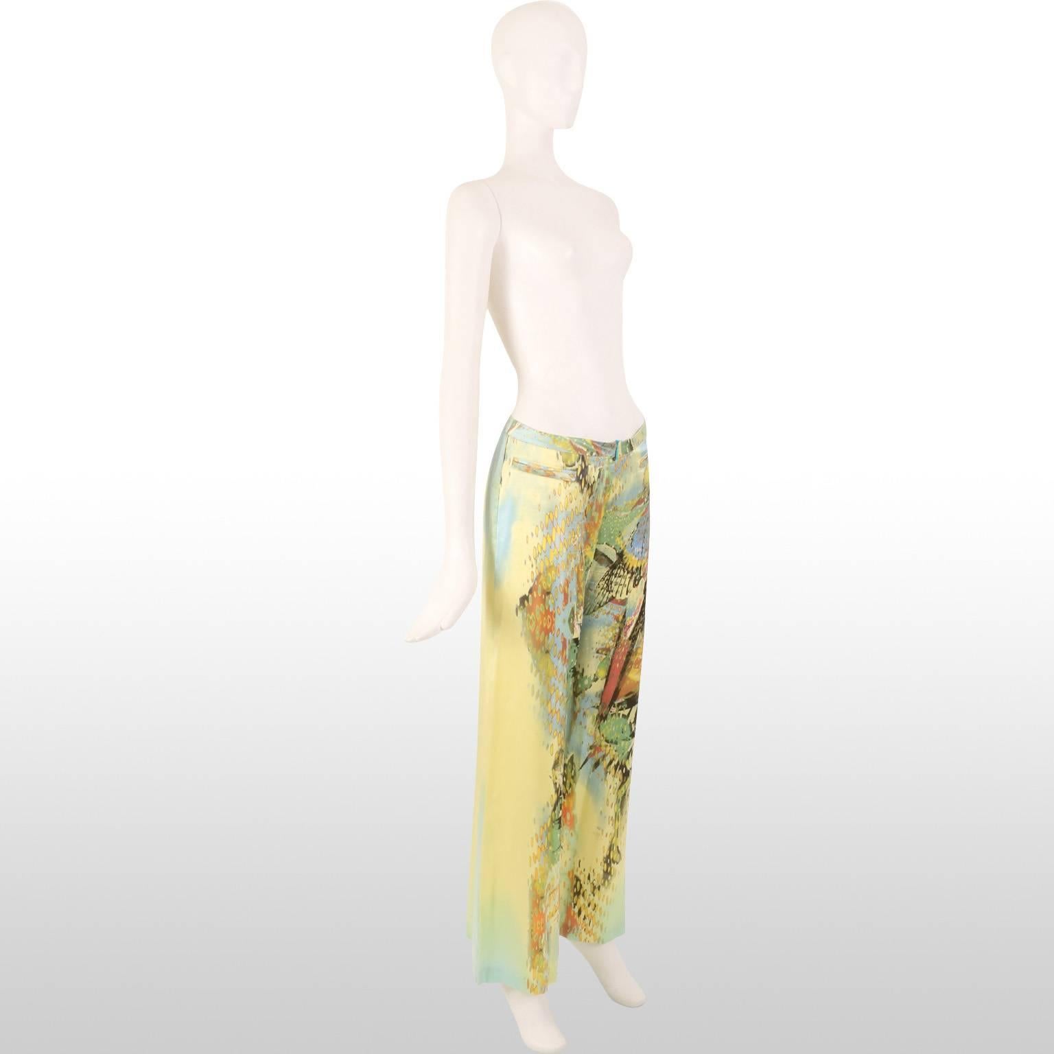 These are trousers by the designer Roberto Cavalli which are made out of a yellow abstract silk pattern. In the pattern one can vaguely identify a parrot. There are two horizontally aligned front hip pockets and the sape of the rousers go straight