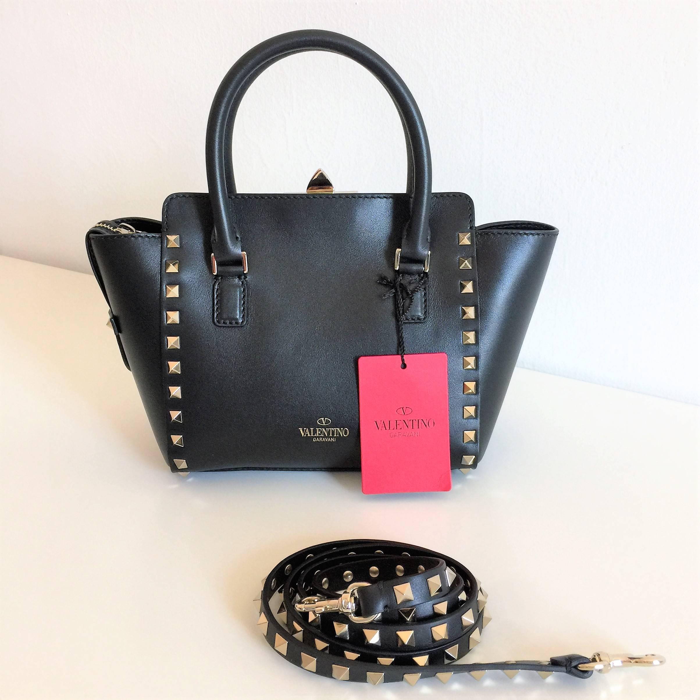 This is an unworn, new with tag, Valentino Garavani Rockstud mini, very elegant hand bag made in black leather with gold stud details. Flip lock closure and zip closure. Detachable studded strap. Cotton lining. Internal open pocket. Gold logo hot