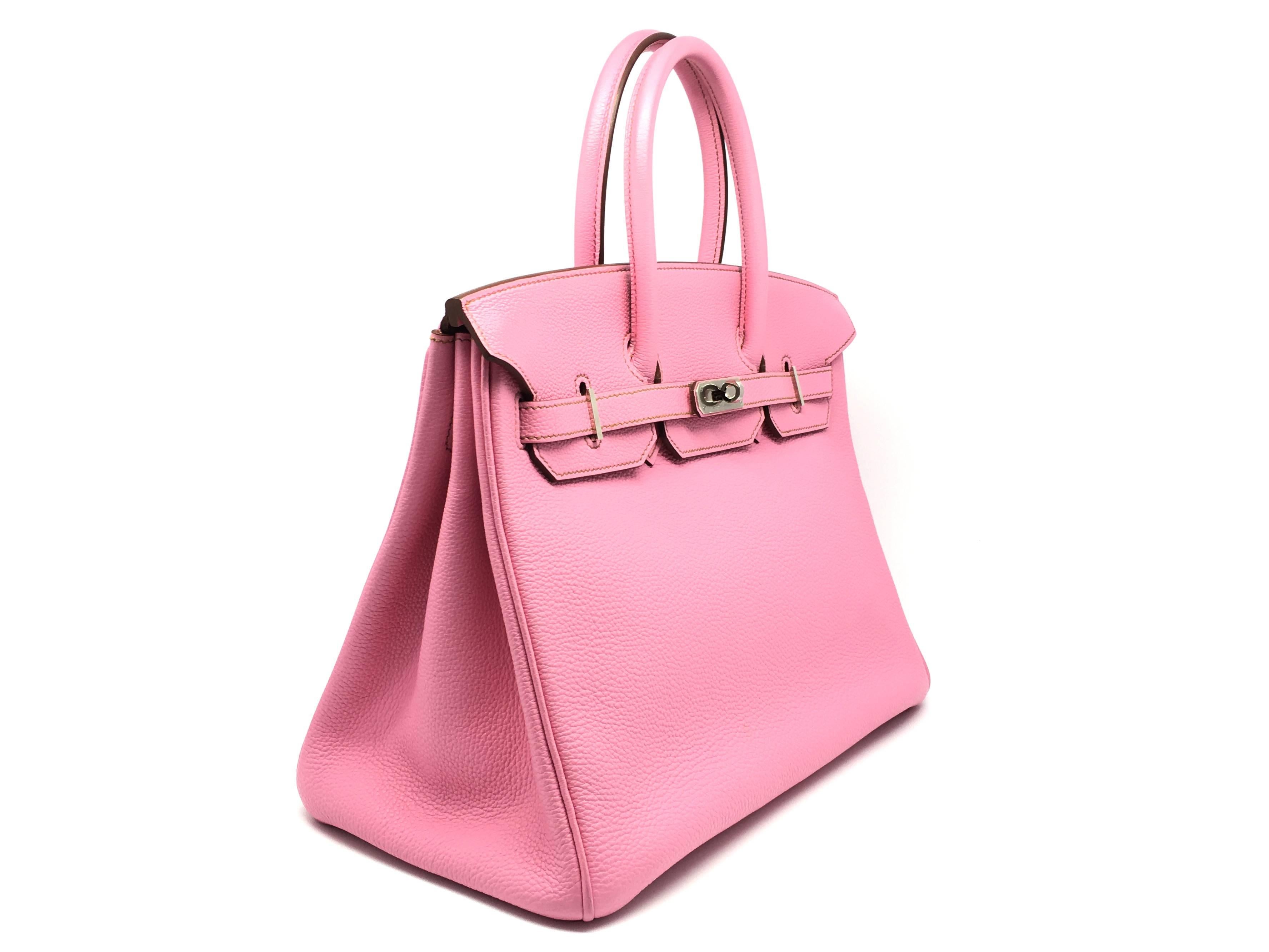 Color: Pink / Rose Shocking (designer color) 

Material: Togo Leather 

Condition: Rank A 
Overall: Good, few minor defects. 
Surface: Minor Stains
Corners: Minor Scratches
Edges: Minor Scratches
Handles/Straps: Minor Stains
Hardware: