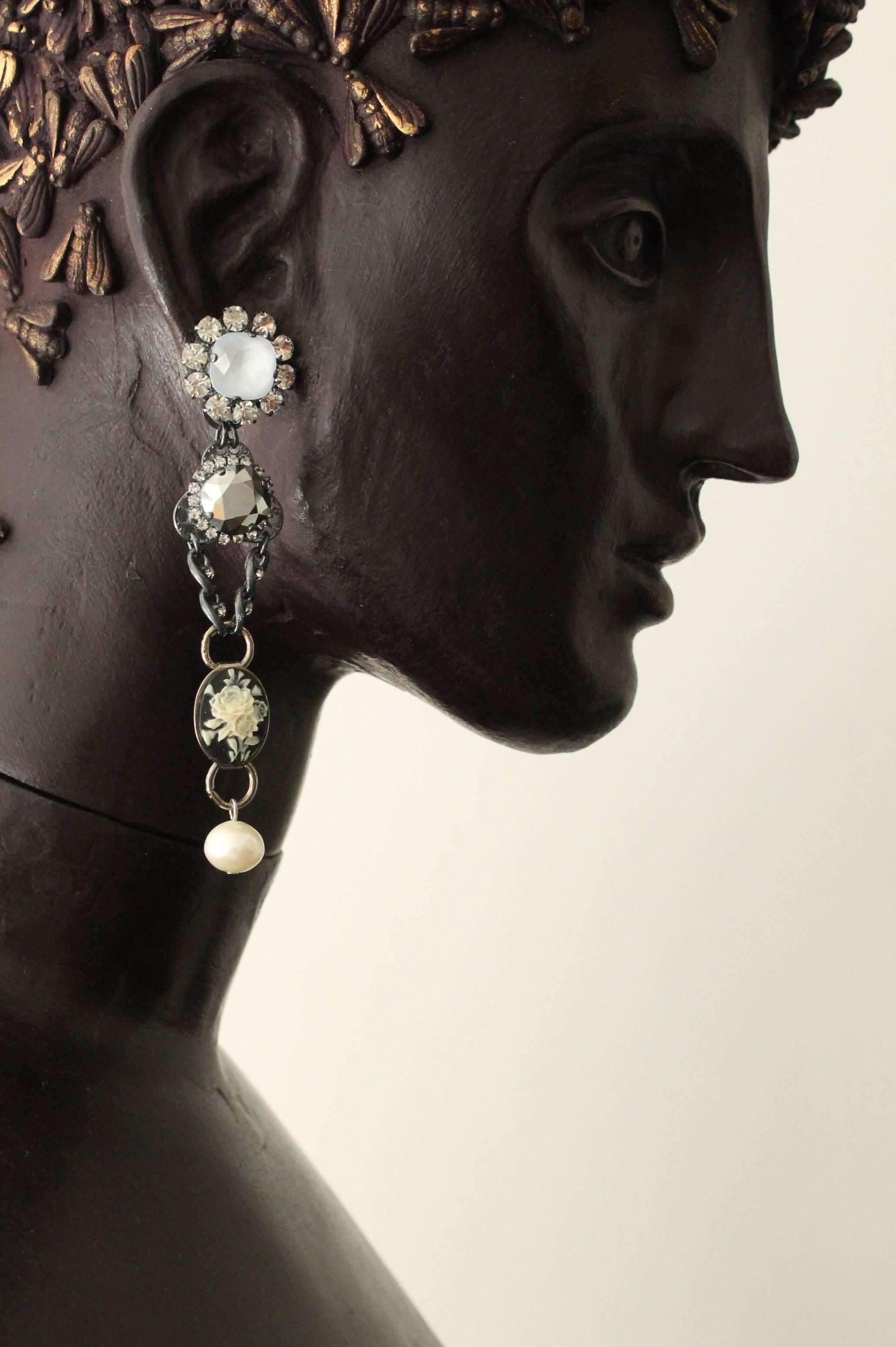Stunning antique silver-plated earrings featuring silver mirror and white hand enamelled Swarovski crystals, asymmetric cameo cabuchons and Swarovski pearls

Handmade for the past 25 years by Vicki’s small team of artisans, in the brand’s Belgravia