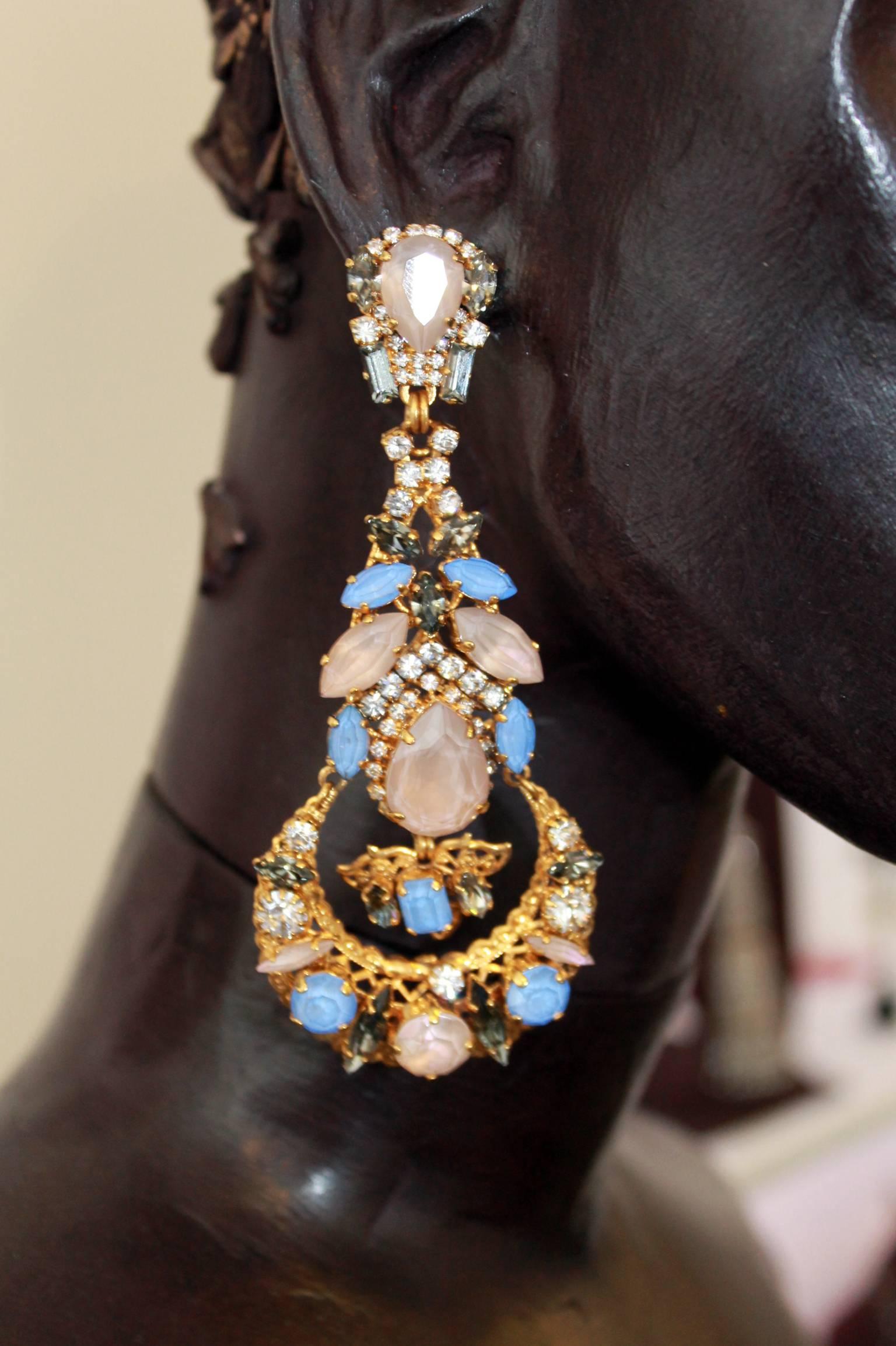 
Dazzling chandelier earrings created using only the finest light-catching Swarovski crystals in ultra-feminine tones of forget-me-not blue and nude. These stunning, elaborate earrings are finished in a subtle 'antiqued' gold-plate detail to