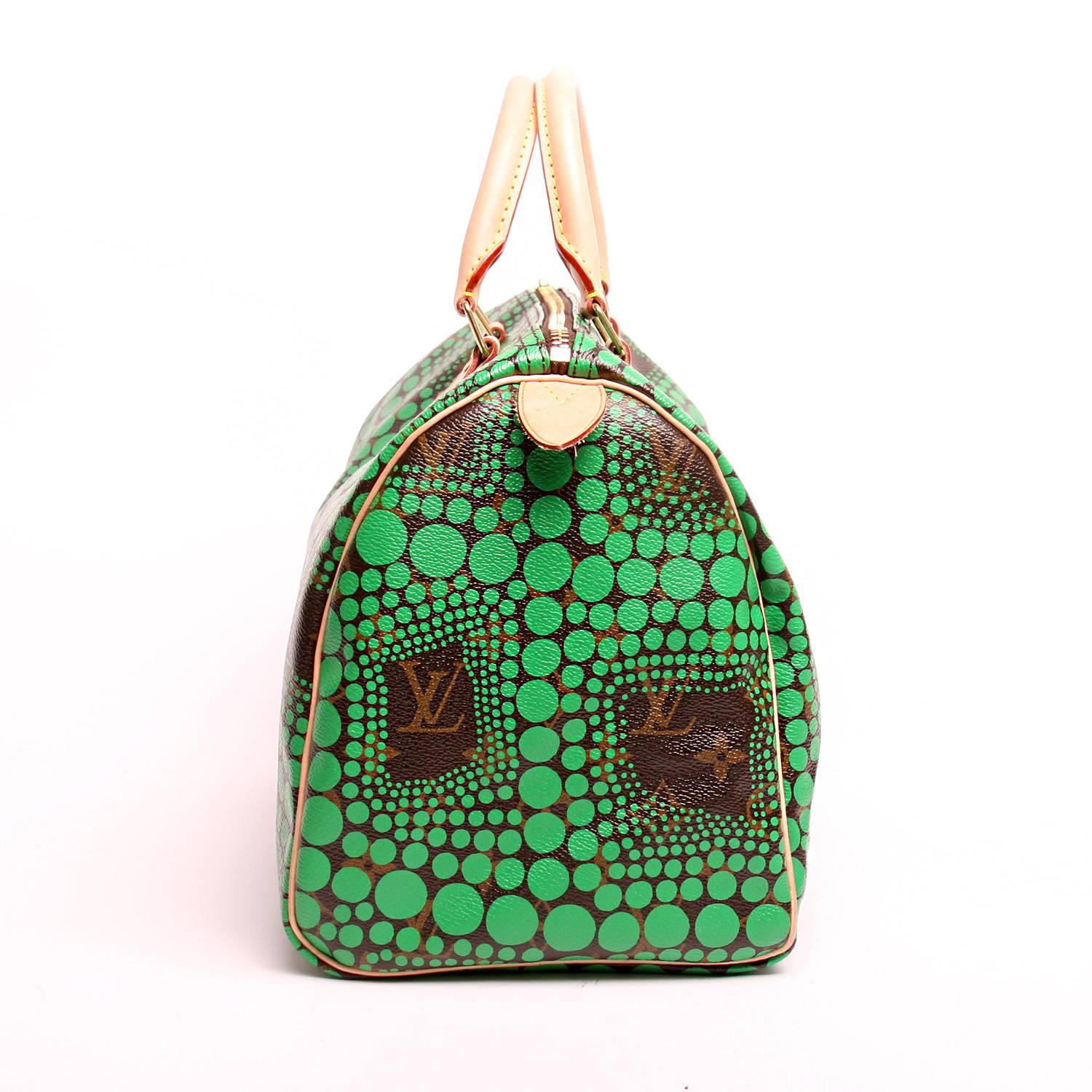From Louis Vuitton’s Yayoi Kusama collection. This stunning Speedy tote features a graphic polka dot pattern from artist Yayoi Kusama printed in green on traditional brown Louis Vuitton monogram toile canvas. The bag features vachetta cowhide rolled
