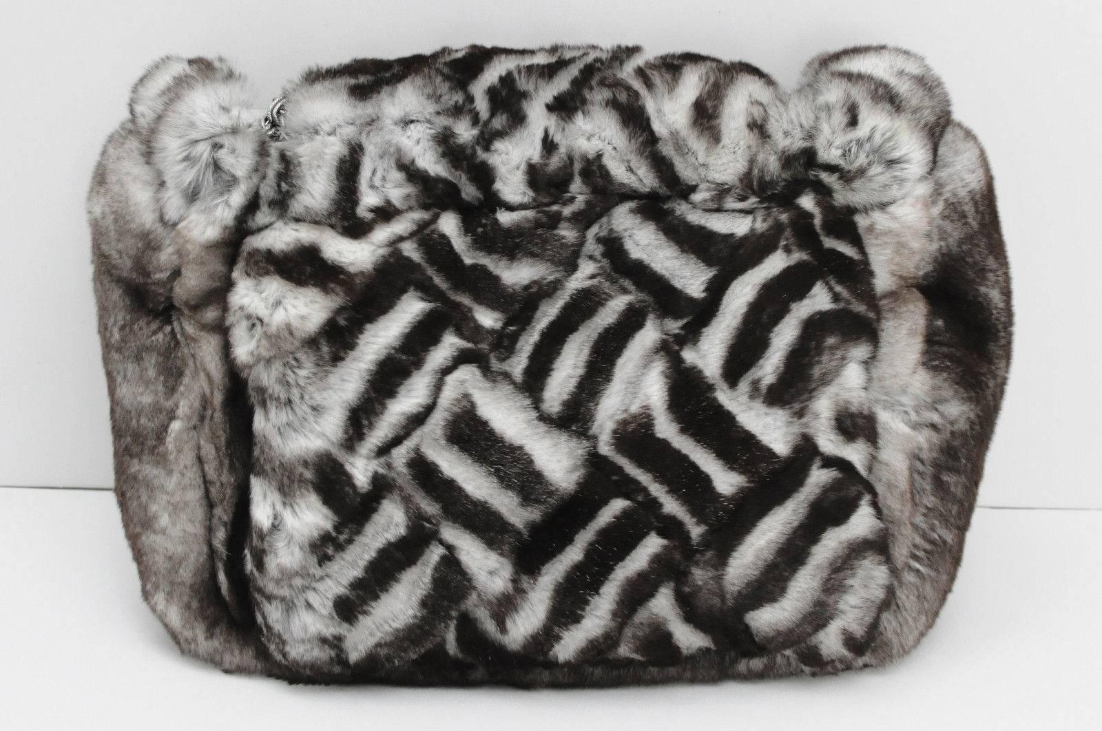 This authentic Limited Edition Chanel Chinchilla fur clutch looks and feels like no other handbag in the world. The luxuriously soft black & white fur covers the entire bag and blends perfectly with darkened silver Chanel 