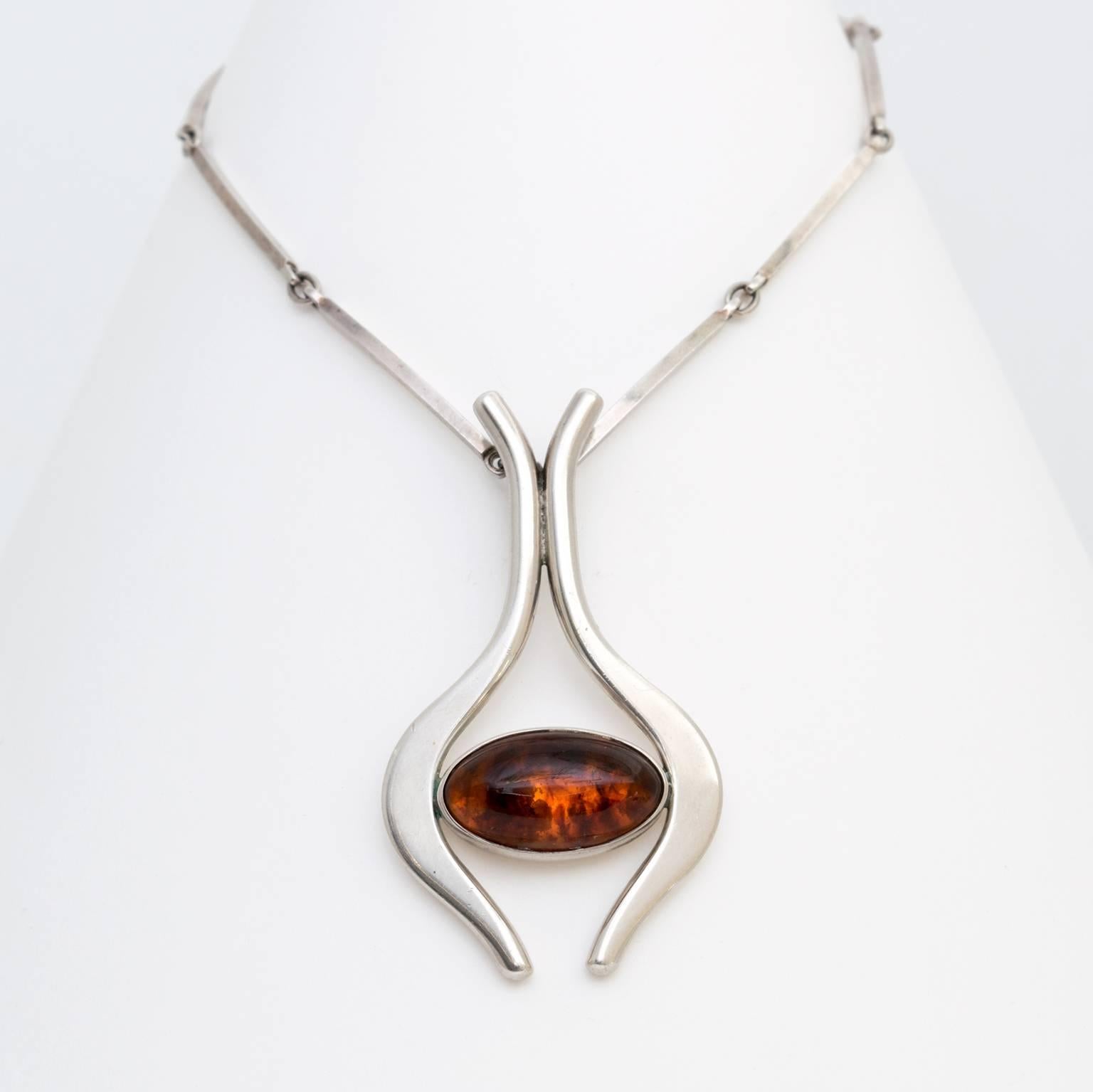 Scandinavian Modern sterling silver necklace and pendant with cabochon in amber. Designed by Niels Erik From, Denmark, 1960's
 
Total Length: 12”, chain 10”, pendant 2.5”
Pendant height: 2.75