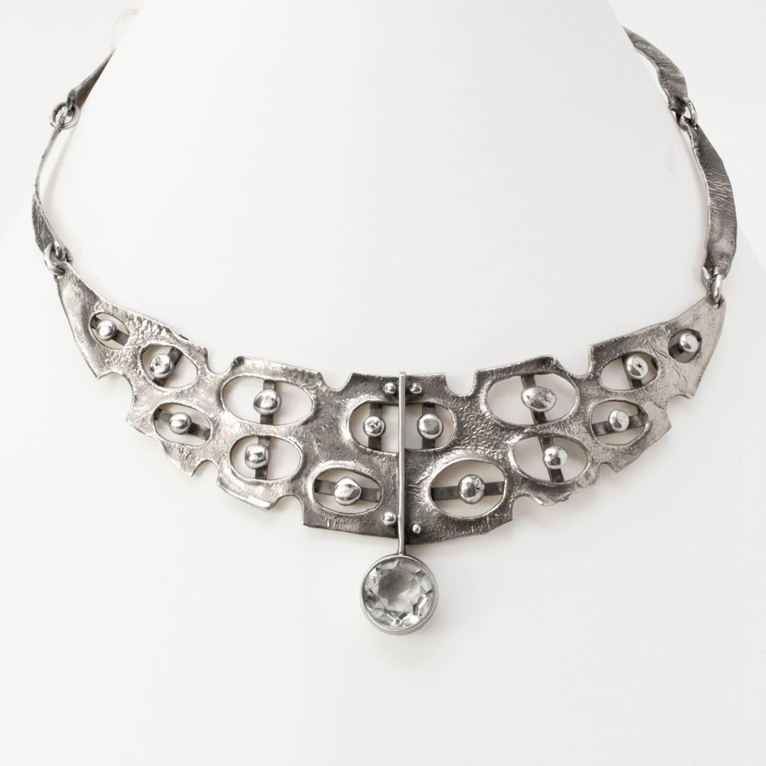 Scandinavian Modern sterling silver necklace with highly textured surface and organic shaped openings. A round faceted quartz crystal adds a geometric detail. Designed by Isaac Cohen, Stockholm, 1965
Diameter: 6