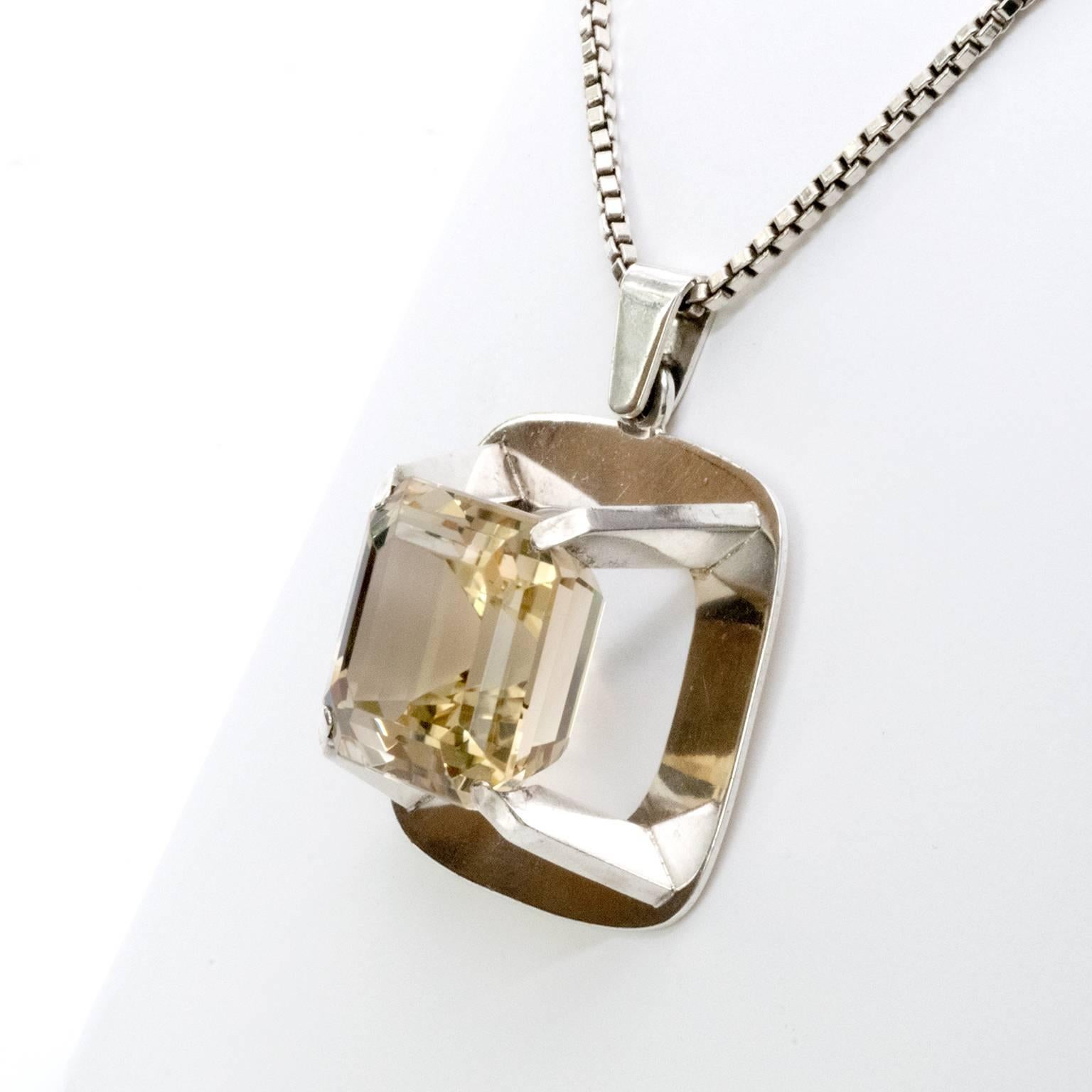 A silver necklace with a rounded rectangular  pendant with a mounted citron rock crystal. Designed by Birger Lindgren, 1967, Stockholm Sweden.
Width: 2