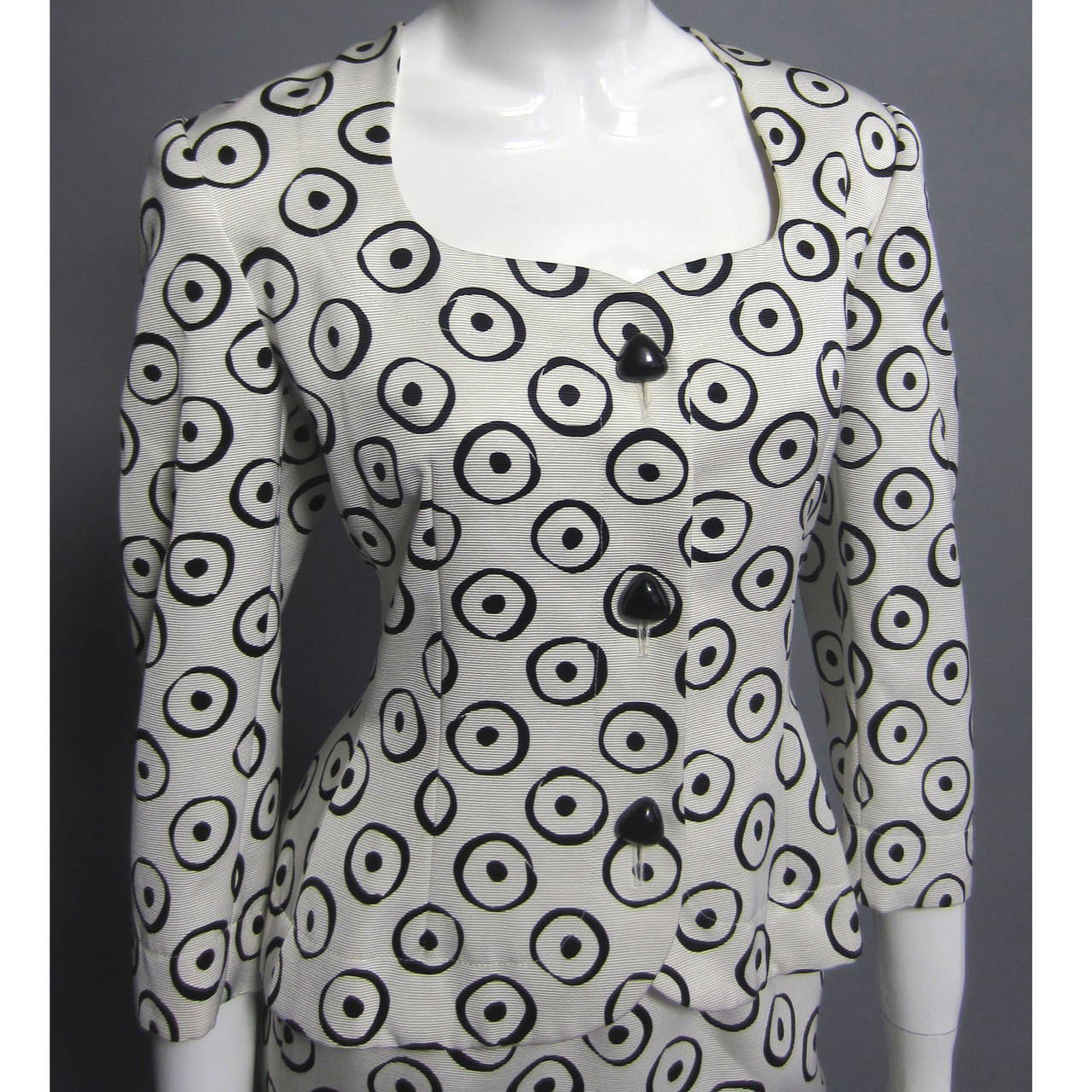 Graphic and on trend, this black and white printed silk skirt suit is a classic piece. Wear together, or wear the pieces separately. The jacket has a fitted waist and is weighted throughout the hem. Black, rounded triangle buttons are further