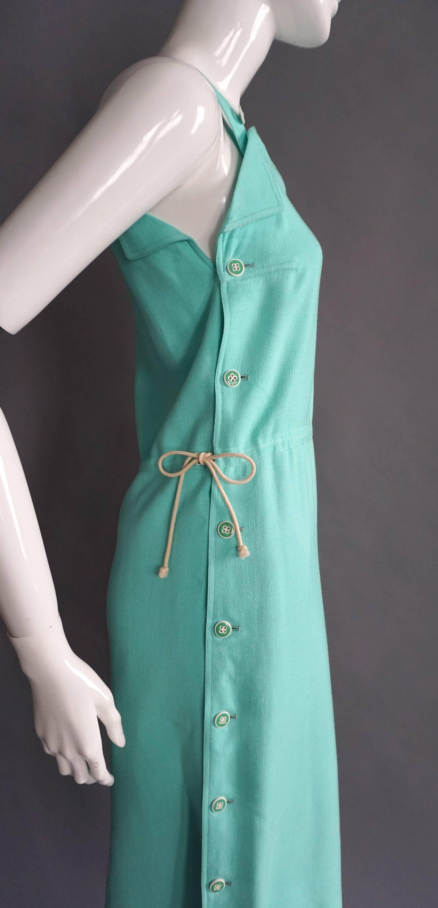 This COURREGES dress is made of a mint green colored, high quality cotton. The dress features straps that are adjustable with two buttons. Those buttons are repeated along the sides, securing the front to the back. The drawstring waist is tied on
