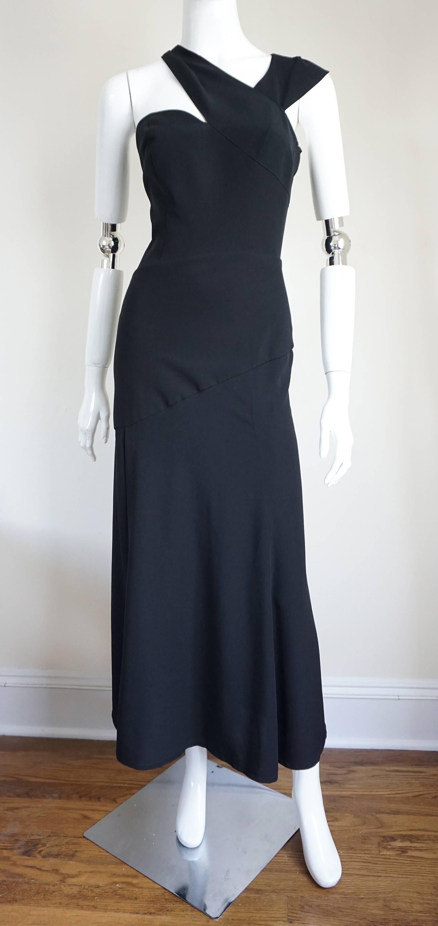 This MUGLER is made of black crepe, which is cut to form to the body. The seam details accentuate the female form. The sweetheart neckline is accented by the double straps that sit on either of the neck. They connect at the back and accented with a