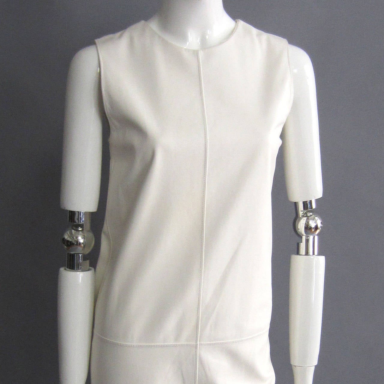 The beautiful white leather of this dress embodies the quality and rich history of HERMES. The subtle leather is soft to the touch, but it is also sturdy, forming the stiff, 60s inspired, shift silhouette. The clean white is modern and classic. A