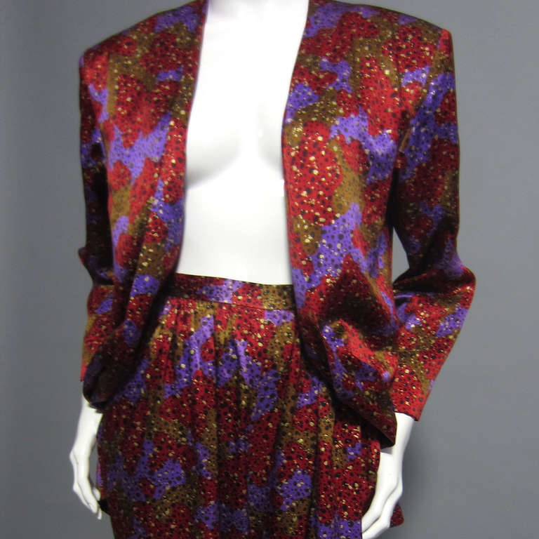 A piece from the master of menswear inspired fashion; the purple, red, brown, and black abstract print silk makes up both the pant and jacket of this stunning suit. The pants sit high on the waist, with slight draping over the hips. Pocket detail.