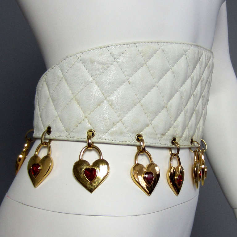 White quilted CHANEL leather belt, 13 hanging gold hearts with red stone centers, Marked CHANEL, slight wear, very good condition.