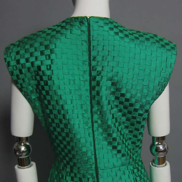 Ribbons of bold, kelly green are woven together to create the beautiful fabric of this dress. The interior of the neck and arm holes are trimmed in matching green silk. Back zipper and hook and eye closure.  Fully lined. Slight shoulder pads add