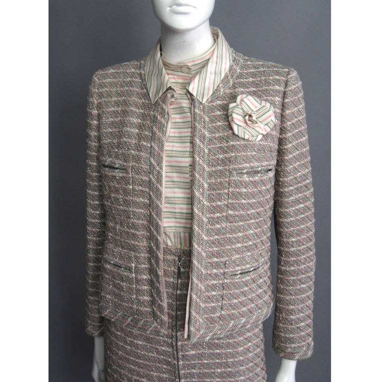There is nothing as classic as a CHANEL suit. Timeless style from the house that CoCo built, this 3 piece suit is versatile and beautiful. The suit is comprised of a sleeveless blouse, tweed a line skirt, and matching tweed jacket. Beginning with