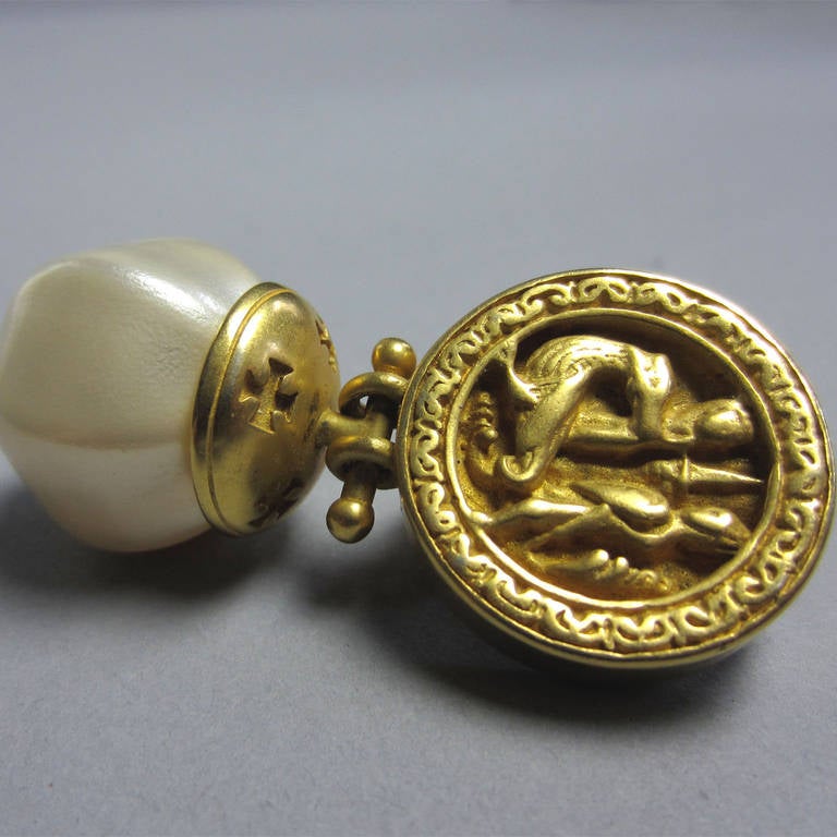 Vintage Ann and Catherine Prevost Pearl Drop Earrings. The intricate details of this earrings are remarkable. The gold circle that sits on the ear features a ornate tableau; it appears to be two people, perhaps knights, and what looks like a gryphon
