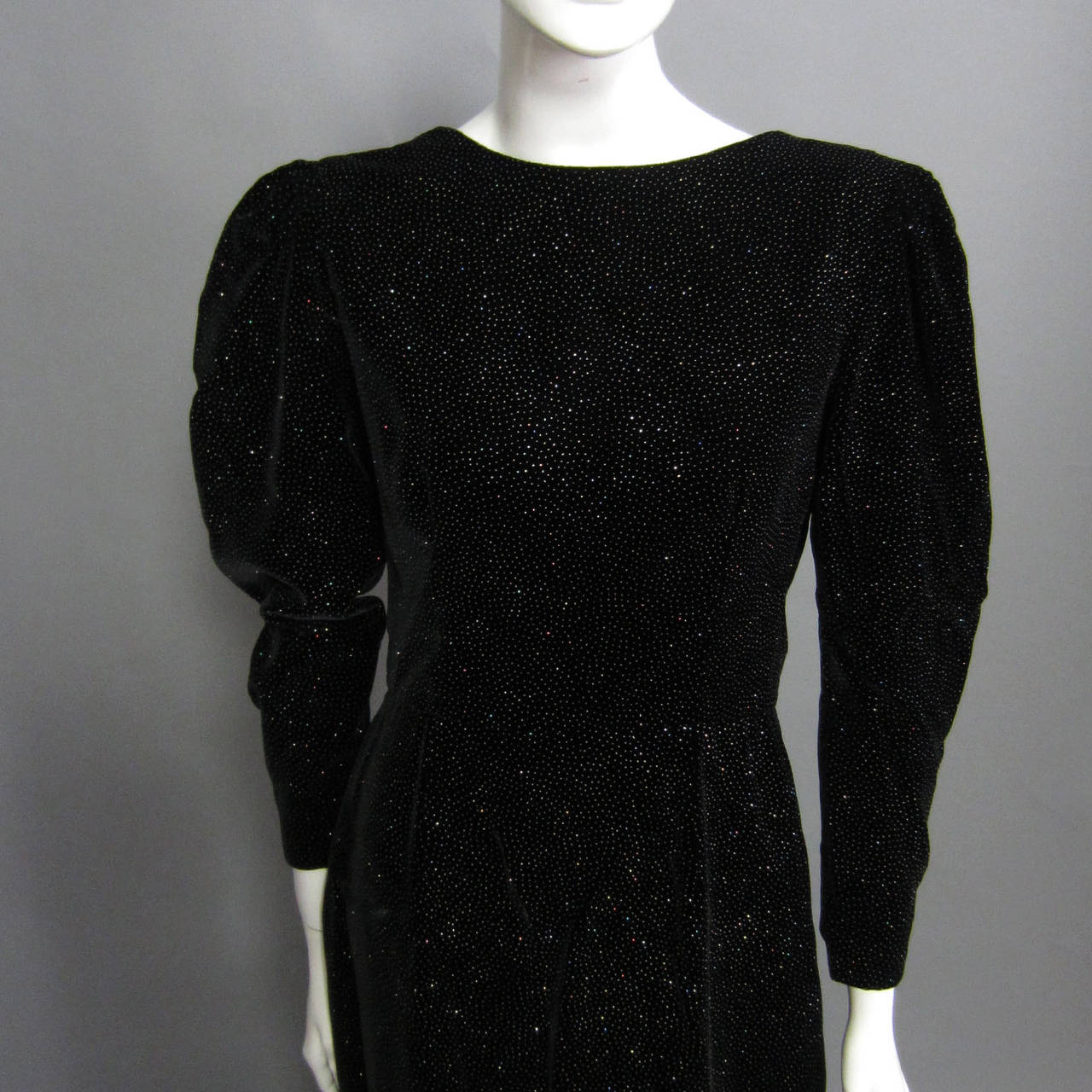 The fabric of this LANVIN gown is exquisite. The black velvet is covered with silver glitter inlayed in the fabric. The fabric resembles the look of a clear, starry night sky; the sparkles reflect and refract light. The puff sleeve detail accented