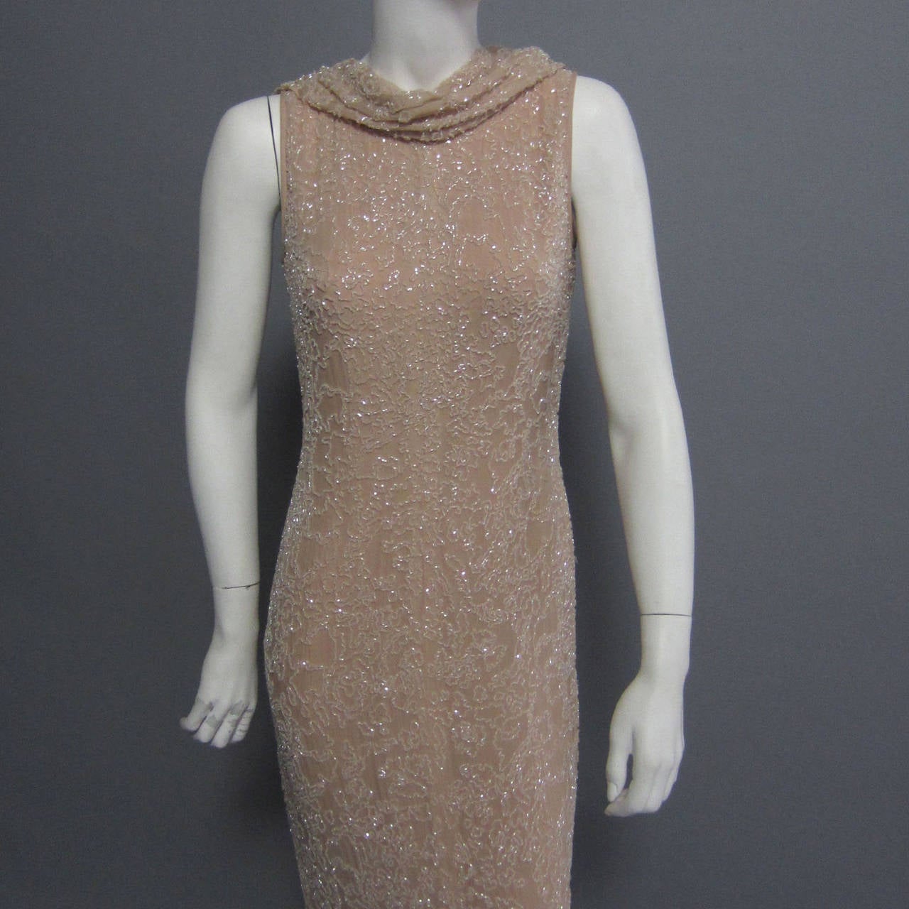 A gorgeous, beaded evening gown by the iconic American designer, HALSTON. The gown is a pastel shade of pink; the pale color is enhanced by the indicate beadwork. The shinny, bugle beadwork covers the entire gown. There is an extra panel of beaded