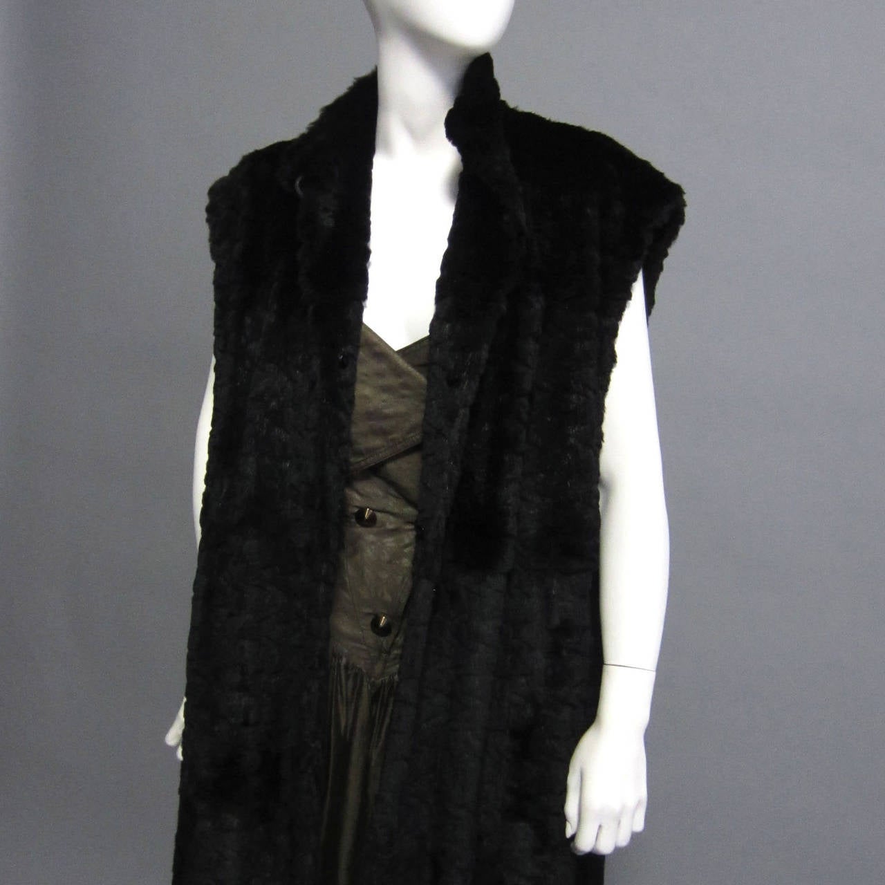 This FENDI Coat is really two pieces in one; a black swing coat, and a fur maxi vest. The two pieces can be worn together, or separately. The coat is made of black wool. The dolman sleeves are accented by the pleating detail at the shoulders. The