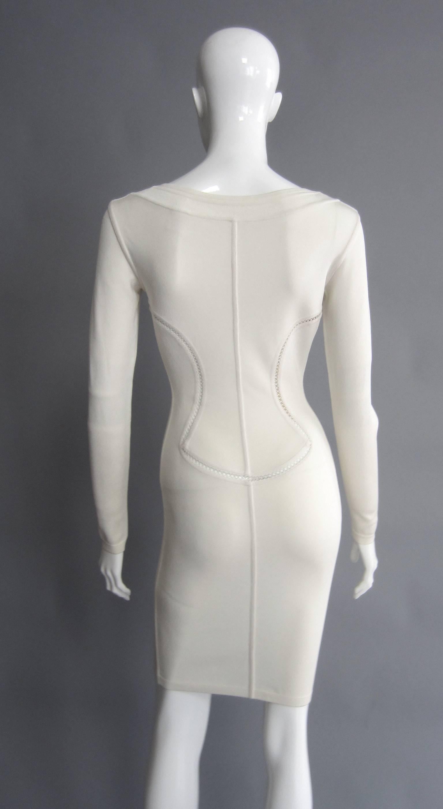Classic 1990s ALAIA fitted Dress featuring lattice detailing, The cut out lines strategically curved to hug the body, with the lattice detail filling the space in between. Long Sleeve. Wide Neck line with ribbed detail.

Fabric Label Reads: 90%
