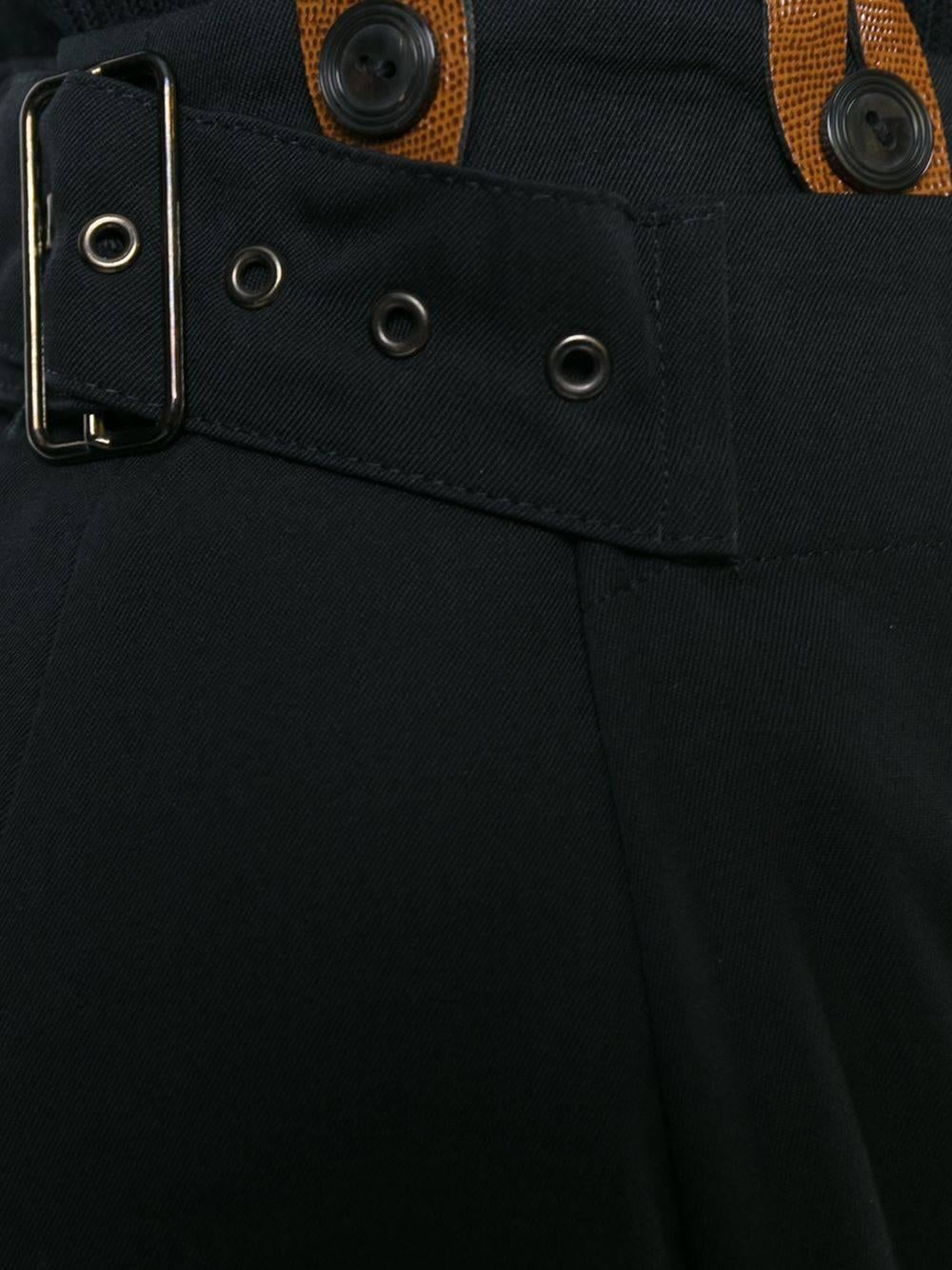 Black wool suspender apron trousers from Jean Paul Gaultier Vintage featuring a high rise, a waistband with belt loops, a side buckle fastening, a wide leg and a rear welt pocket. Please note that vintage items are not new and therefore might have
