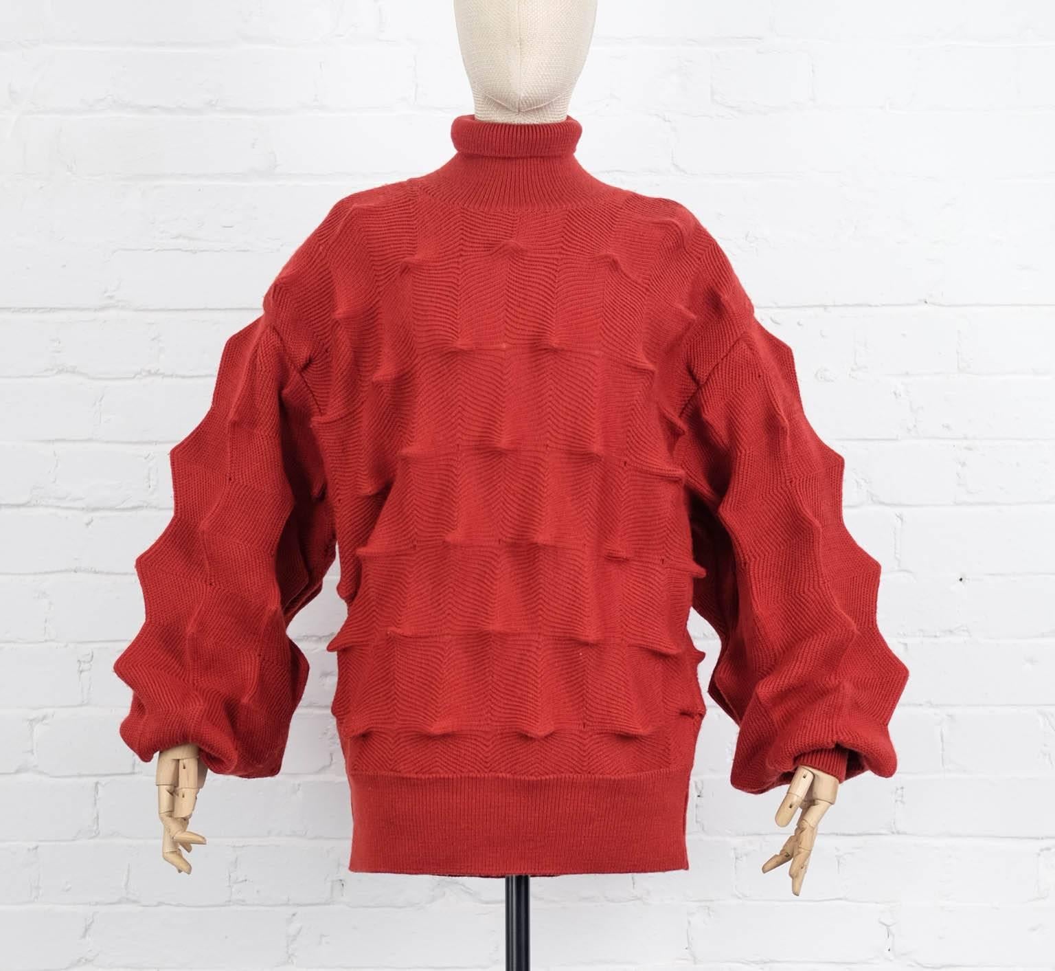 Brick red wool roll neck sweater from Issey Miyake Vintage featuring long sleeves, a ribbed hem and cuffs and a zig-zag fabric cut. Circa 1970
