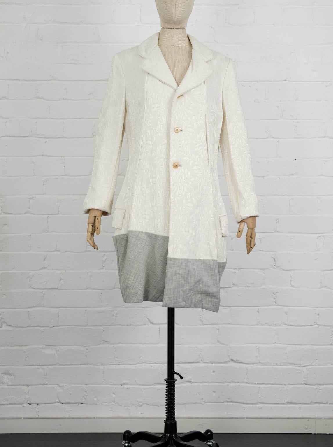 Cream wool contrast hem jacquard coat from Comme Des Garçons Vintage featuring notched lapels, a front button fastening, long sleeves, side flap pockets, a grey checked hem, a short length and a straight hem. Spring 1993