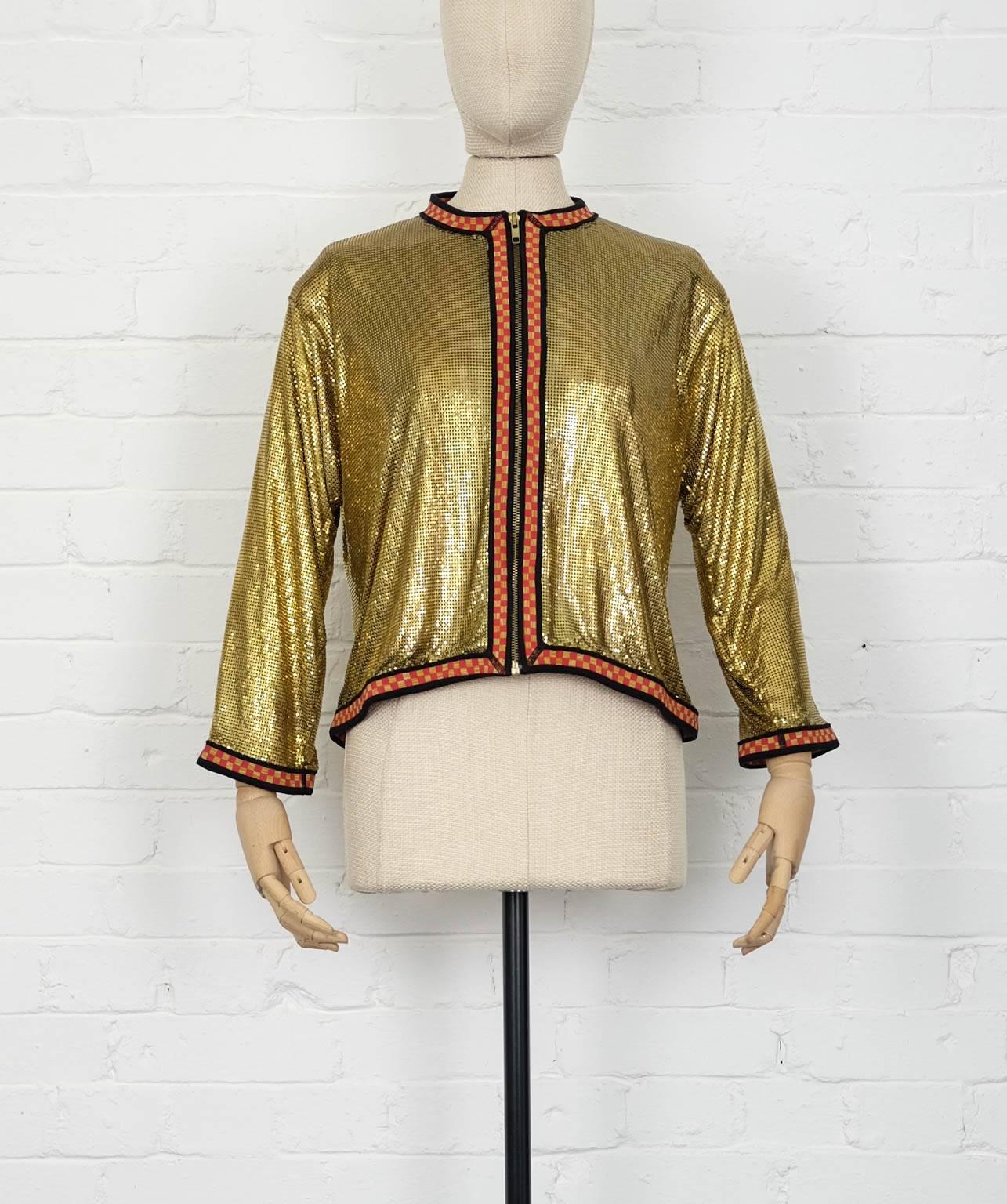 Gold-tone metal and cotton blend chainmail effect jacket from Jean Paul Gaultier Vintage featuring a collarless design, a red and yellow checkboard effect trim, a front zip fastening, three-quarter length sleeves and a cropped length.
This item is