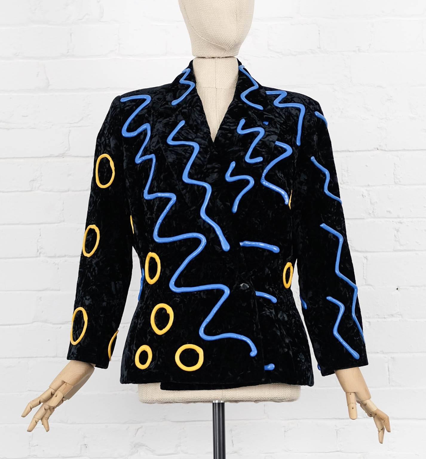 Black crushed velvet jazzy patterned jacket from Kansai Yamamoto Vintage featuring a wide lapel, long sleeves, a front button fastening and a blue and yellow rubber jazzy pattern. Excellent condition.



Shoulder:
41 cm
Sleeve length:
53 cm