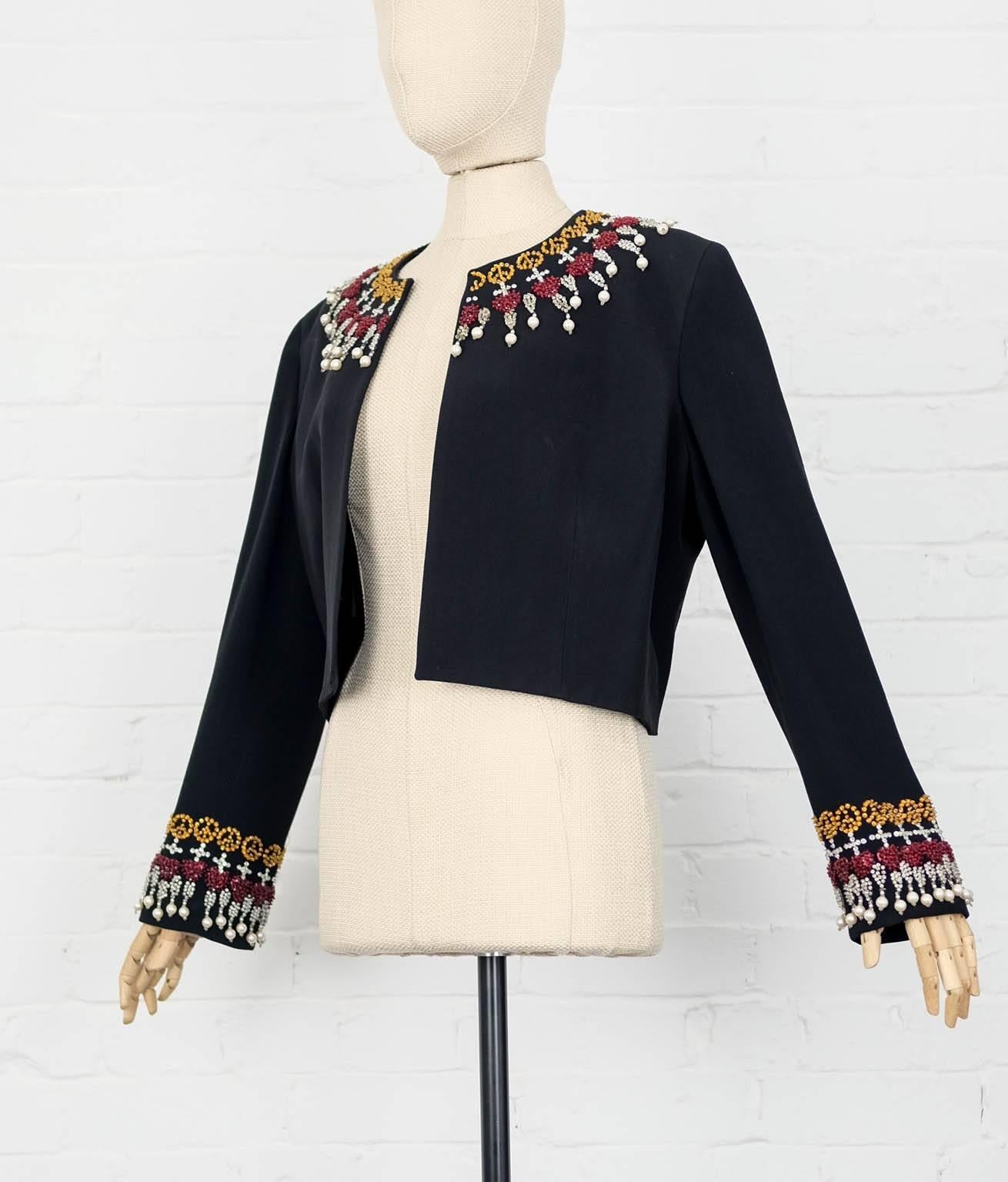 Moschino Vintage Black, red and gold-tone embellished cropped jacket 
featuring a round neck, an open front, beaded embroidery, long sleeves, a straight hem and faux pearl embellishments.

Mesurements:
Total lenght 46 cm
Waist 106 cm
Bust 112
