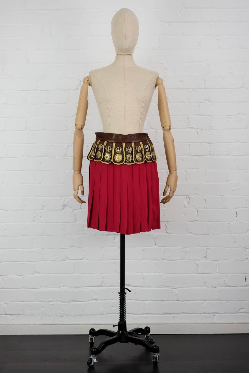 1989 Moschino Couture 'Roman Centurion Soldier' pleated skirt with attached leather belt.

Size 42 IT
Acetate 52% Rayon 48%
Waist 72cm
Length 46cm