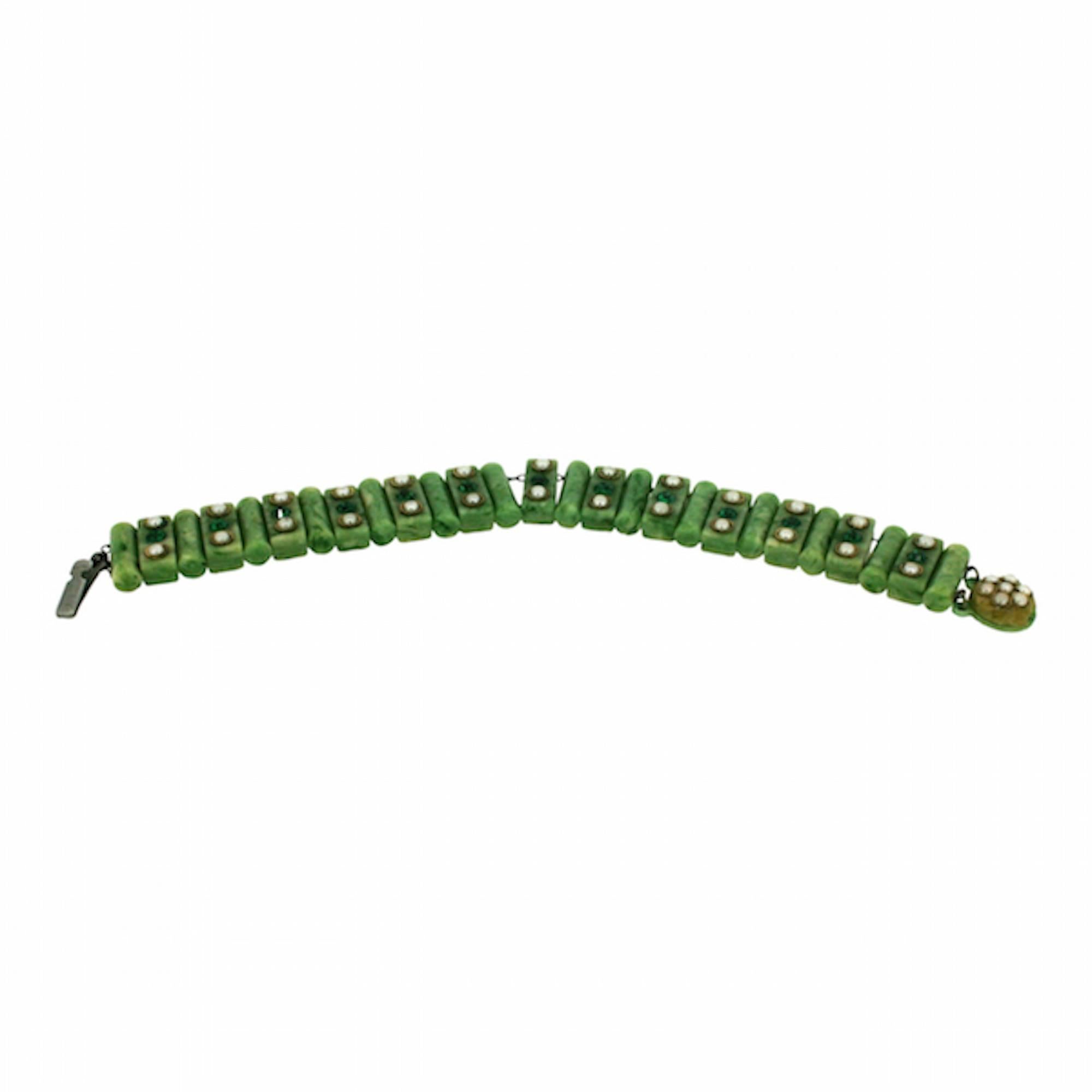 Evocative and unusual, this bracelet dates from the 1930s and is unsigned.

Condition Report:
Excellent

The Details...
This bracelet is made up of green celluloid cylinders and cuboids linked together on a gilt metal chain. Each cuboid is detailed