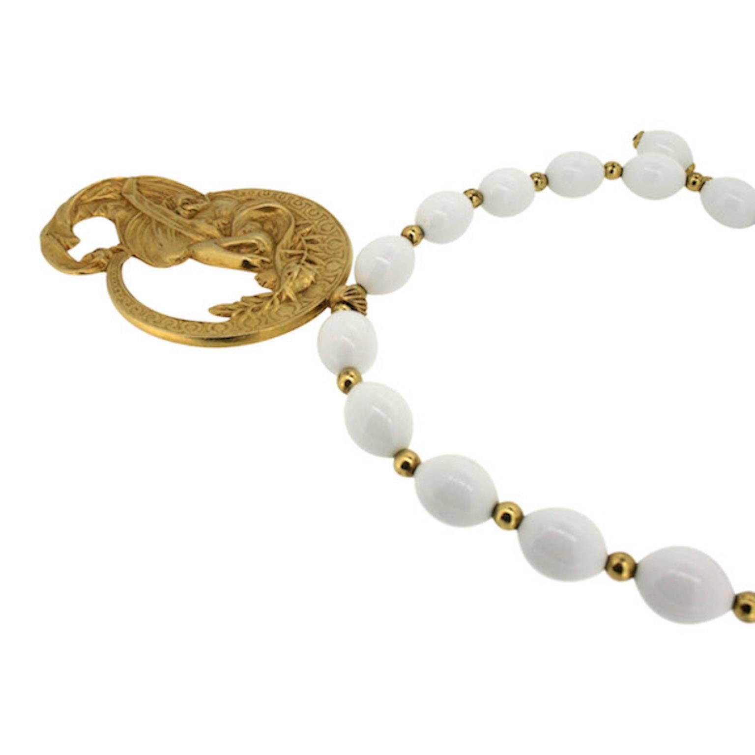 This beautiful necklace featuring Art Nouveau styling was created by Kenneth Jay Lane. It dates from the 1980s.

Condition Report:
Excellent

The Details...
This necklace features large, oval white plastic beads interspersed with small, round gold