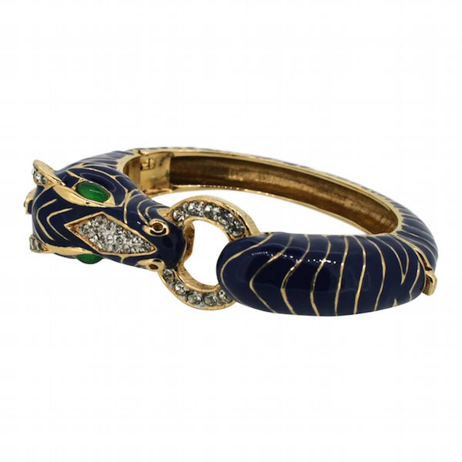 This eye-catching bangle, in a signature design by Ciner, dates from the 1980s.

Condition Report:
Excellent 

The Details...
This gold plated bangle features the Ciner company's signature 'Zebra' design. It features navy enamelling and is detailed