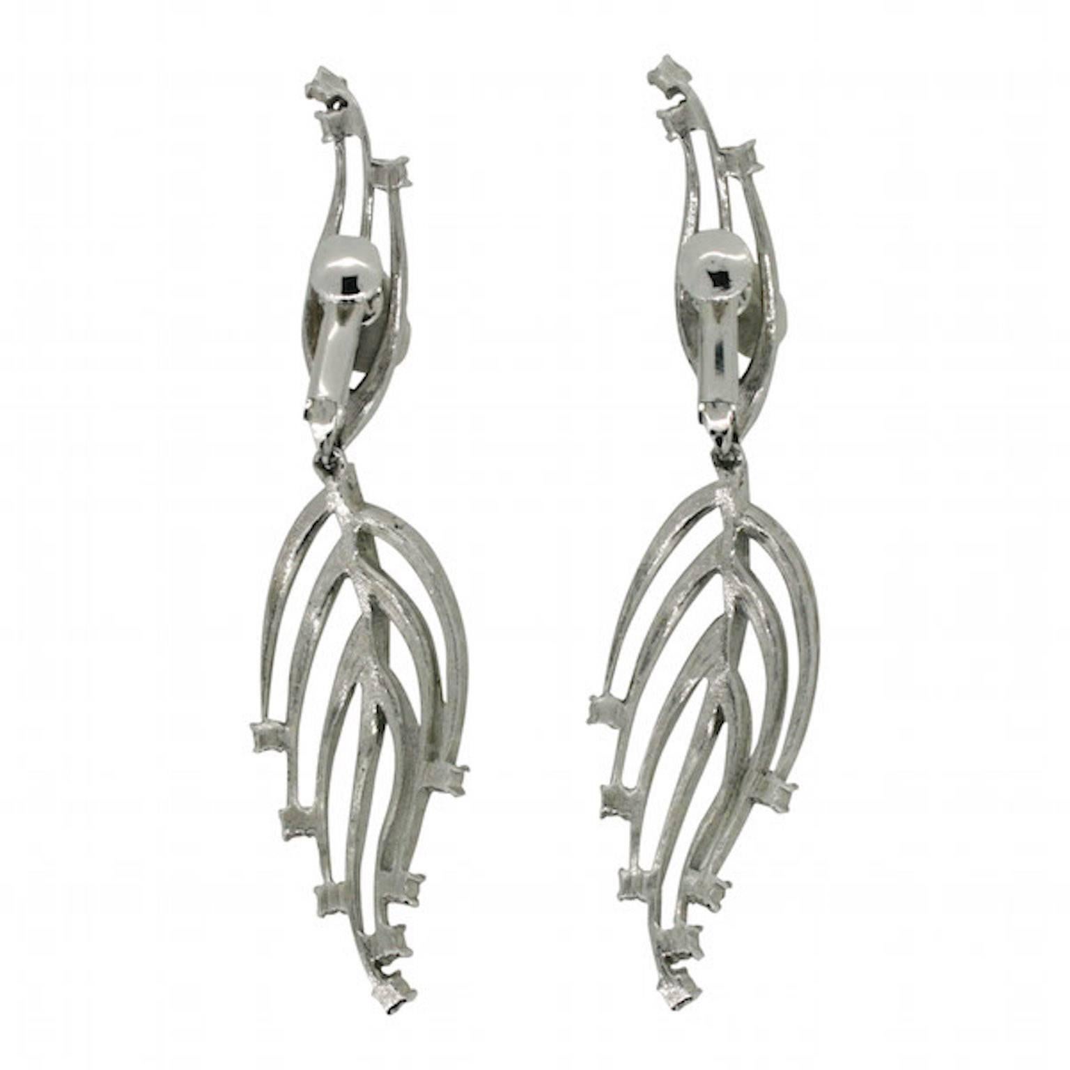 These earrings are a perfect example of the glamorous designs created by American manufacturer, Jomaz, in the 1960s. They are clip on.

Condition Report:
Excellent

The Details...
These rhodium plated earrings feature a 'feather' like design, which