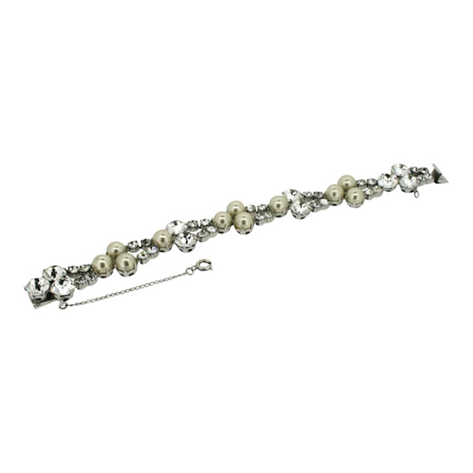 This glamorous bracelet was made by Kramer. It dates from the 1950s.

Condition Report:
Excellent

The Details...
This bracelet features faux pearls and round, faceted diamantes, claw set in silver tone mounts. It fastens with a silver tone book
