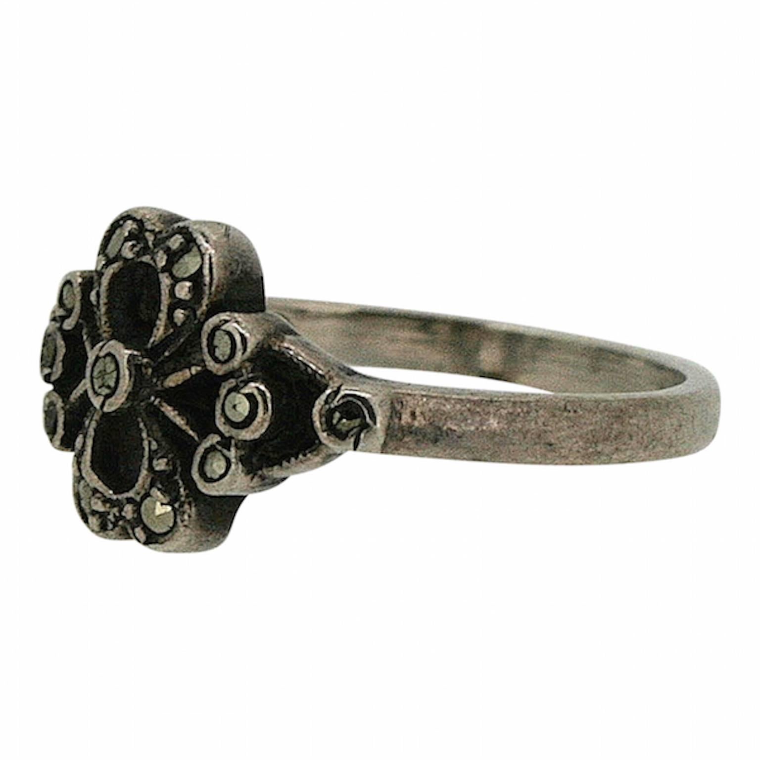Elegant and evocative, this beautiful ring was created in the 1900s and is silver. 
Condition Report:
Excellent
The Details...
This silver ring features a central floral motif detailed with marcasite. The inside of the ring's shank is stamped