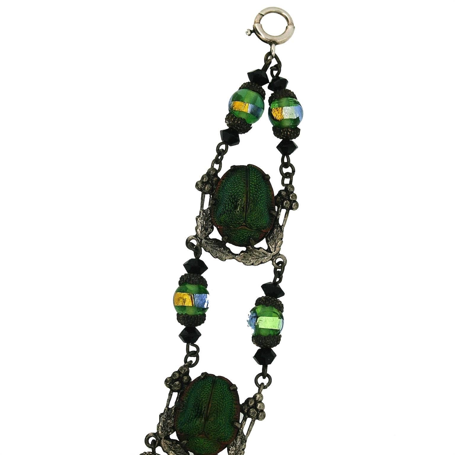 This wonderful bracelet features real beetles and highly collectable peacock foil glass beads. 
Condition Report:
Very Good - The bolt ring catch is possibly more recent than the rest of the piece. This does not detract from the overall appeal of
